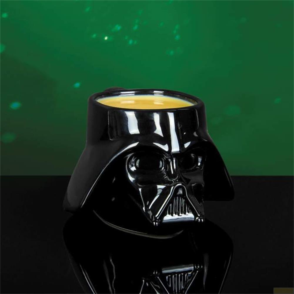 Schwarze Darth Vader Tasse mit gelbem Inhalt vor grünem Hintergrund.