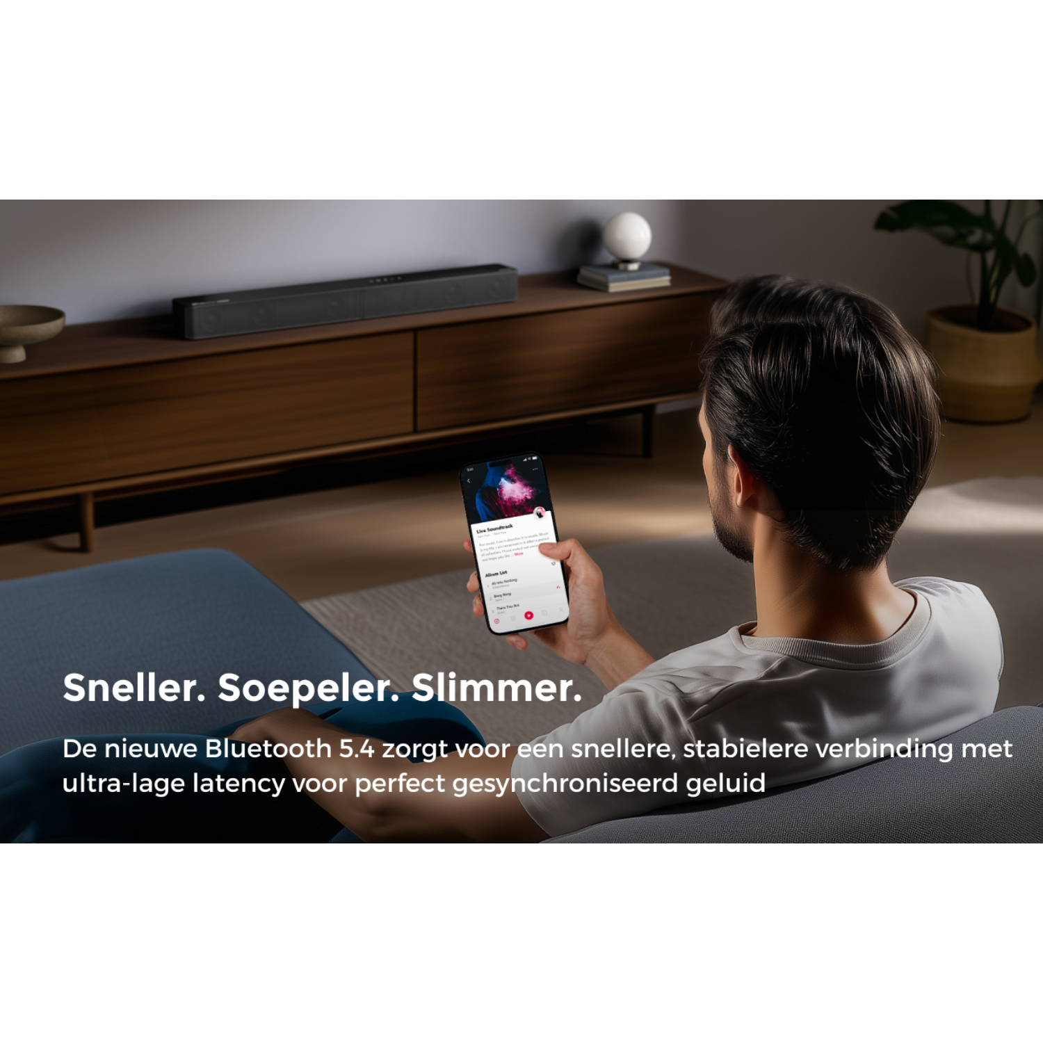 Man holds smartphone with app. Soundbar on wooden furniture. Cozy living room.