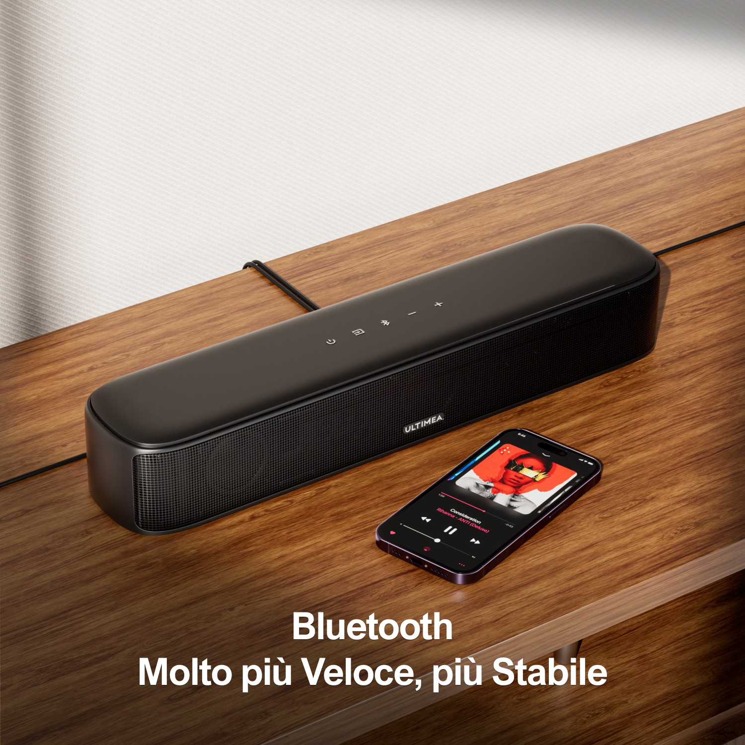 Uno speaker nero e uno smartphone che riproduce musica su un tavolo di legno.