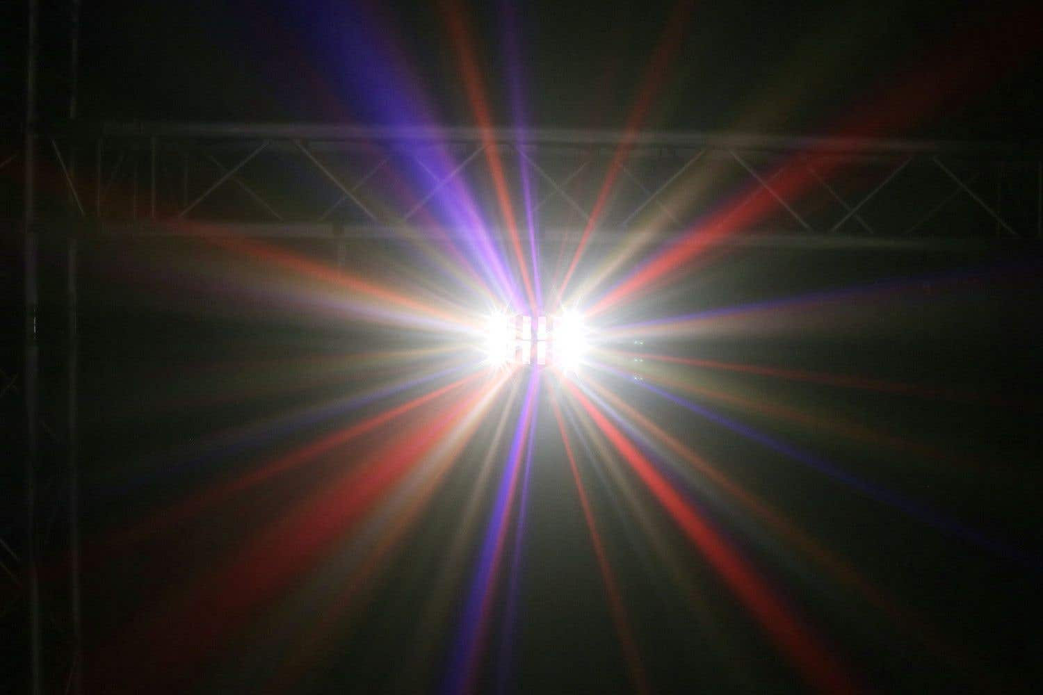 Ein Lichtstrahl fächert sich in Rot und Blau auf, mit einer Traversenstruktur im Hintergrund.