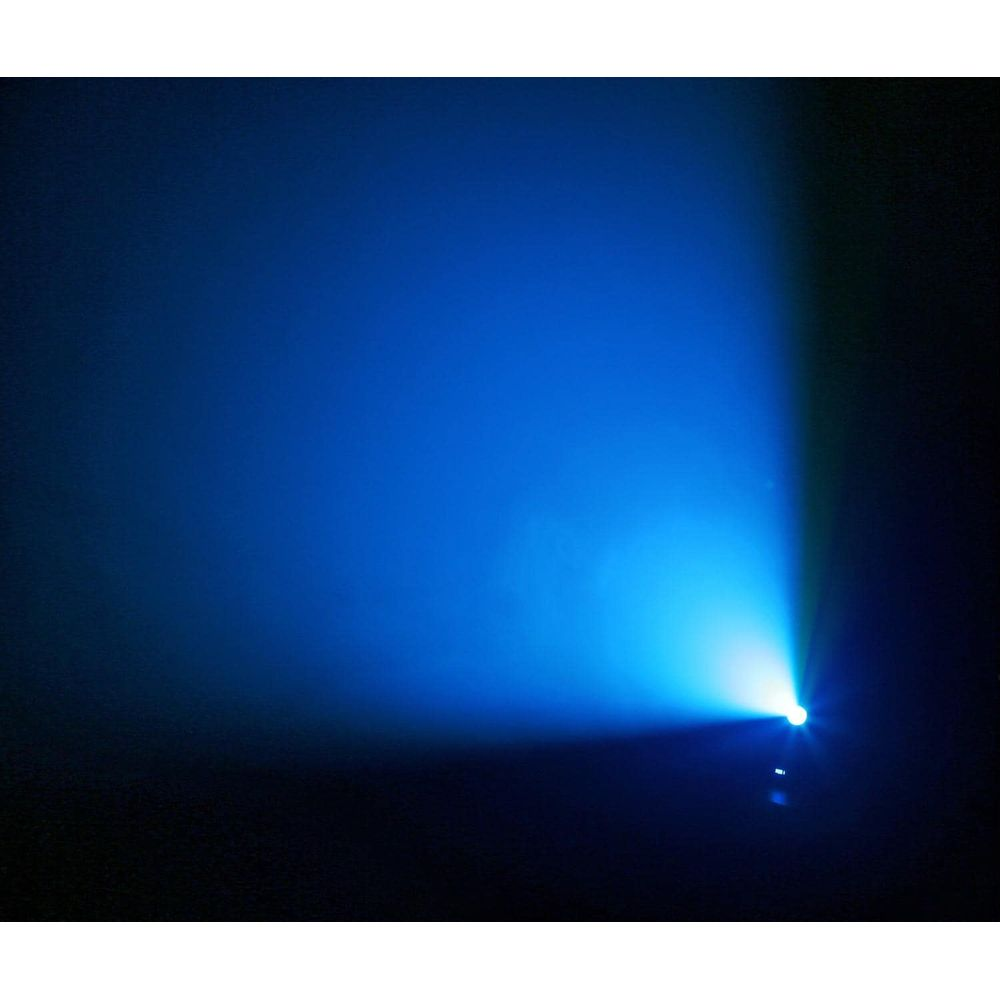 Un foco proyecta un haz de luz azul en una habitación oscura.