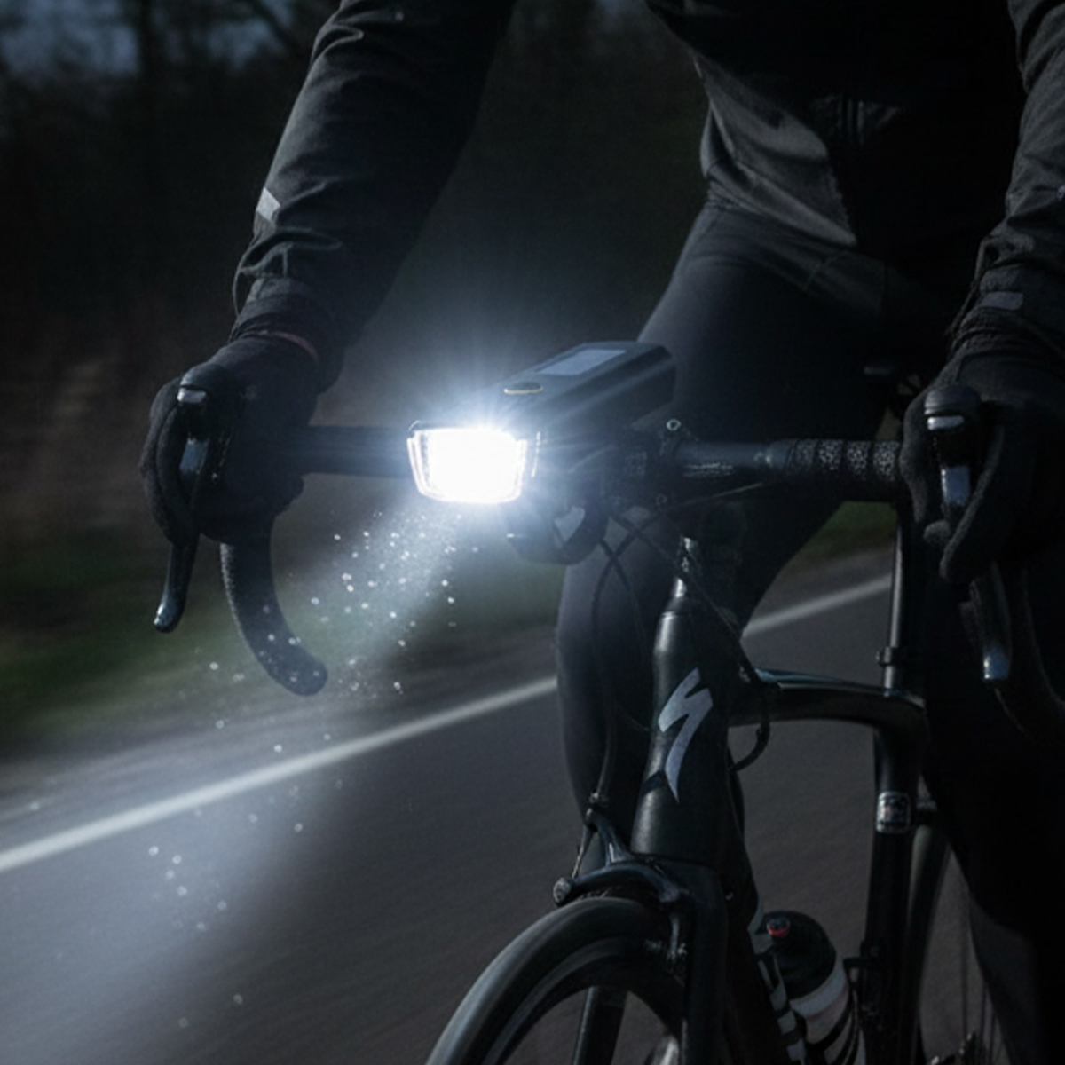 Radfahrer bei Nacht mit hellem Frontlicht auf einer Straße.