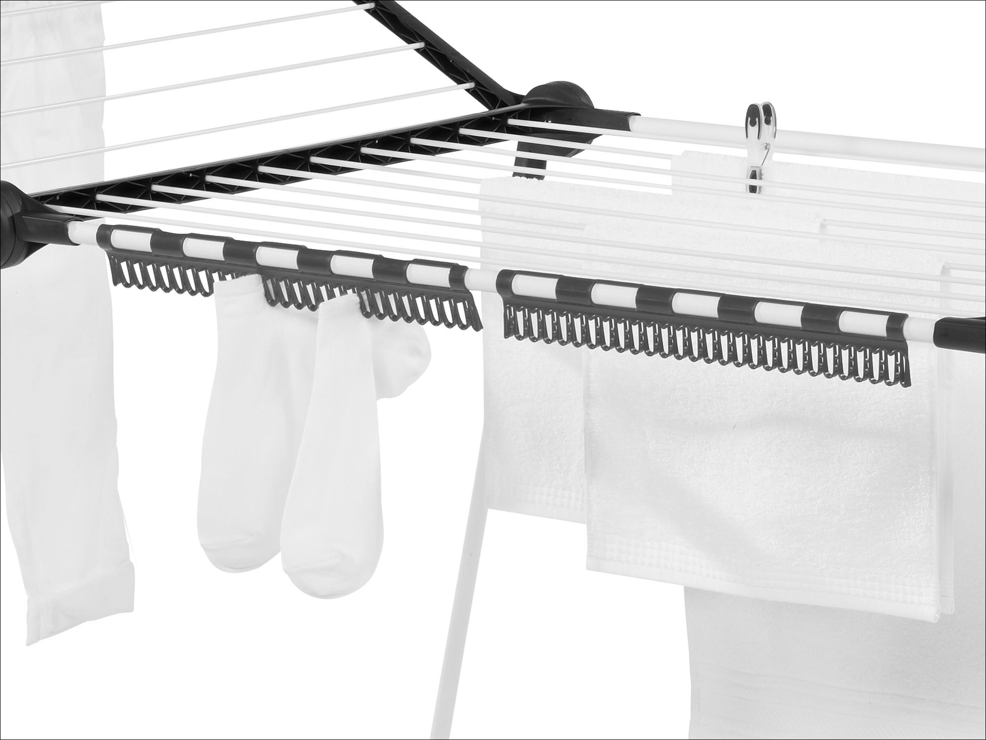 Weiße Socken und Handtücher hängen an einem weißen Wäscheständer mit schwarzen Clips.