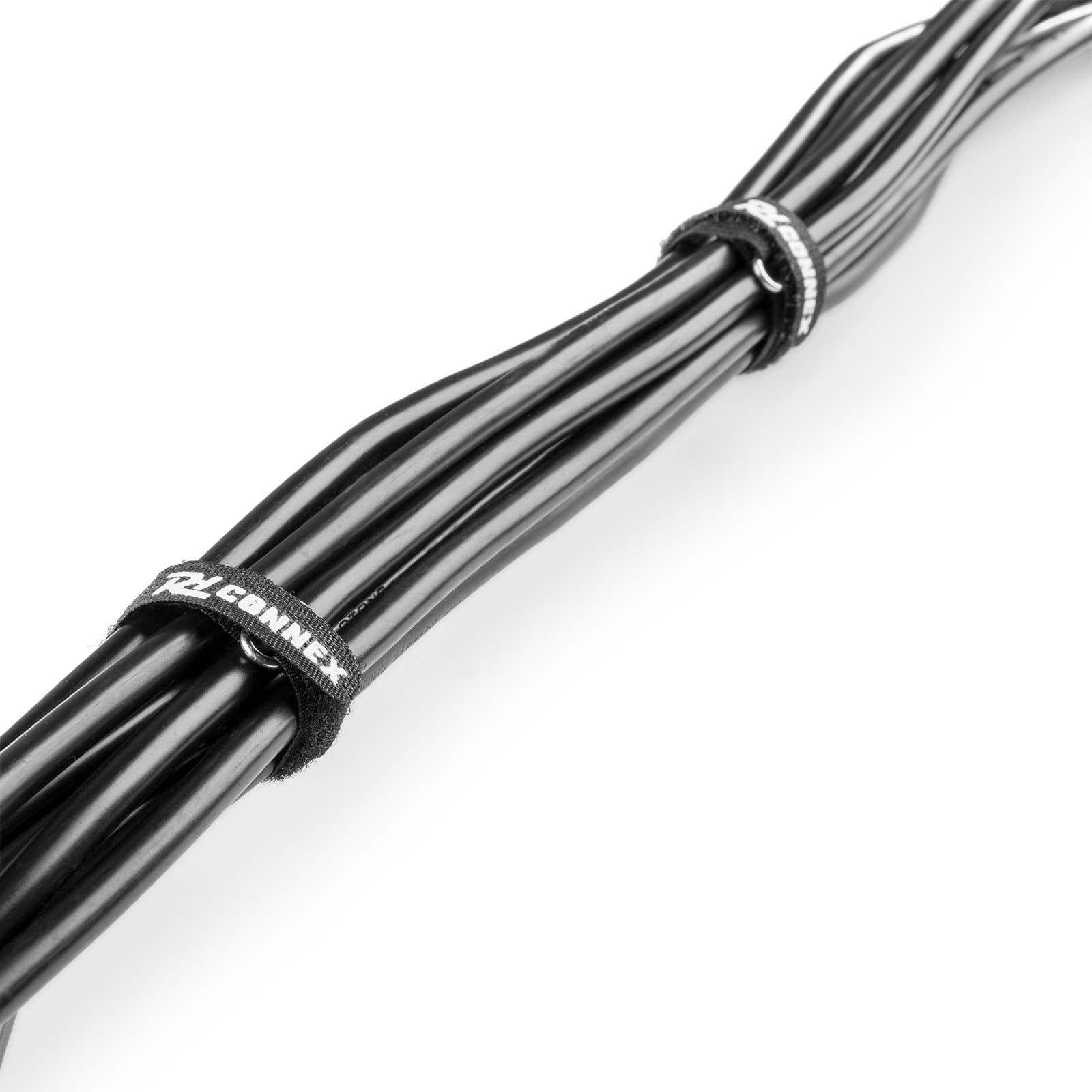 Cables negros atados con una cinta de velcro "CONNEX" sobre fondo blanco.
