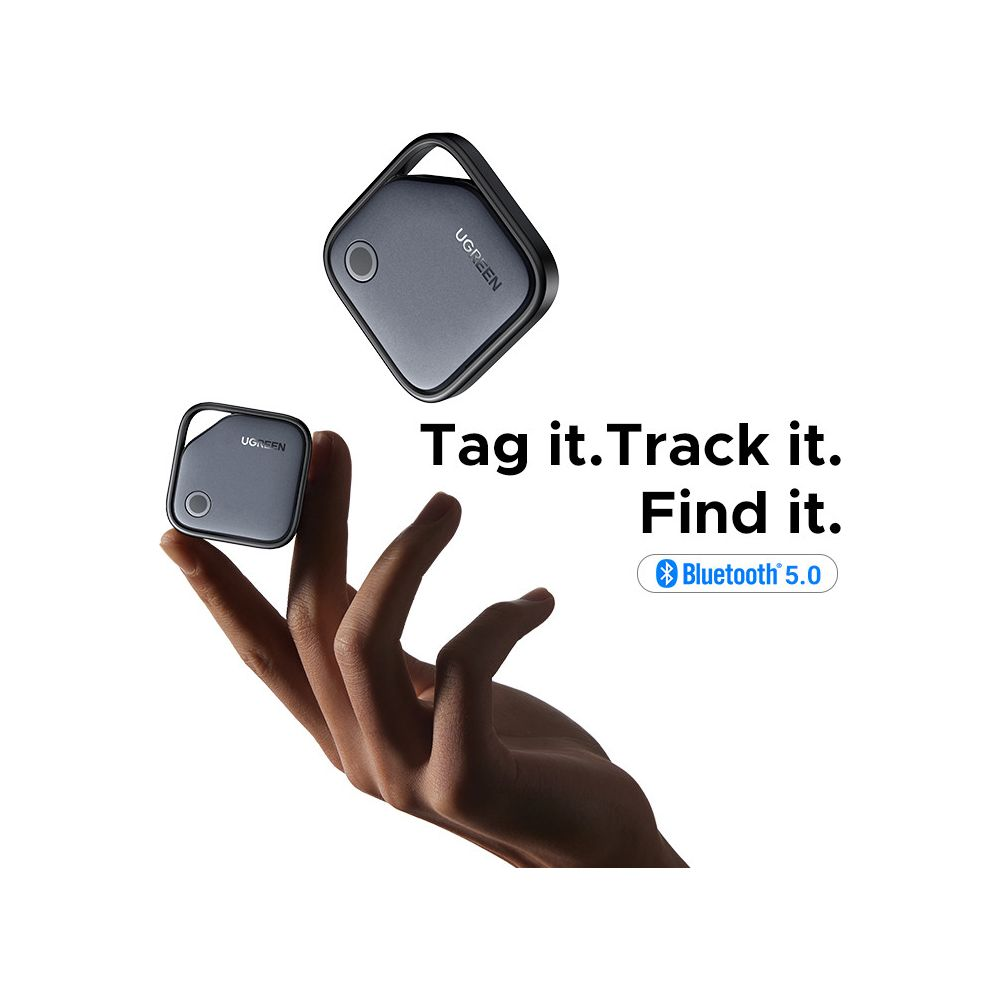 Szary lokalizator Bluetooth 5.0 z logo Ugreen, trzymany przez dłoń.