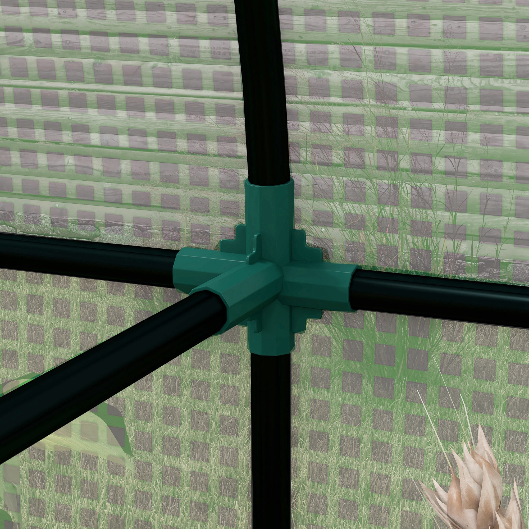 Conector verde con tubos negros contra pared de madera y hierba.