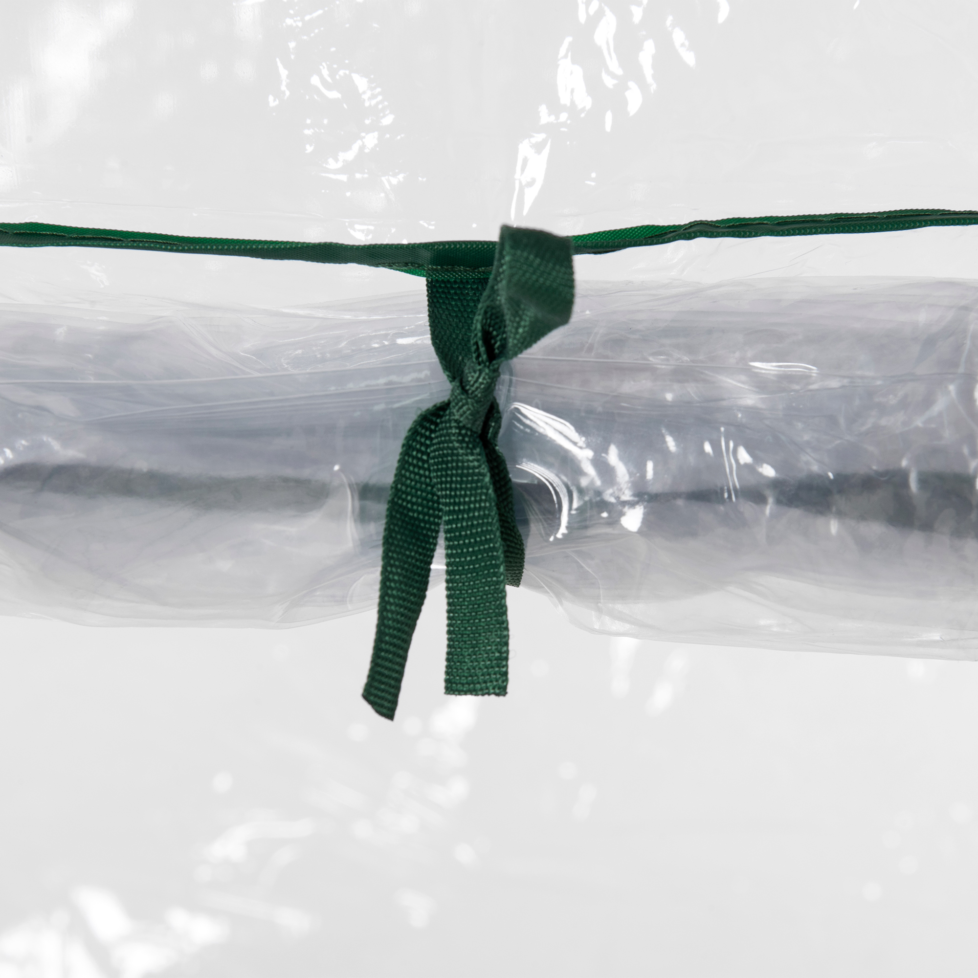 Una cinta verde está atada alrededor de una envoltura plástica transparente que encierra algo oscuro.