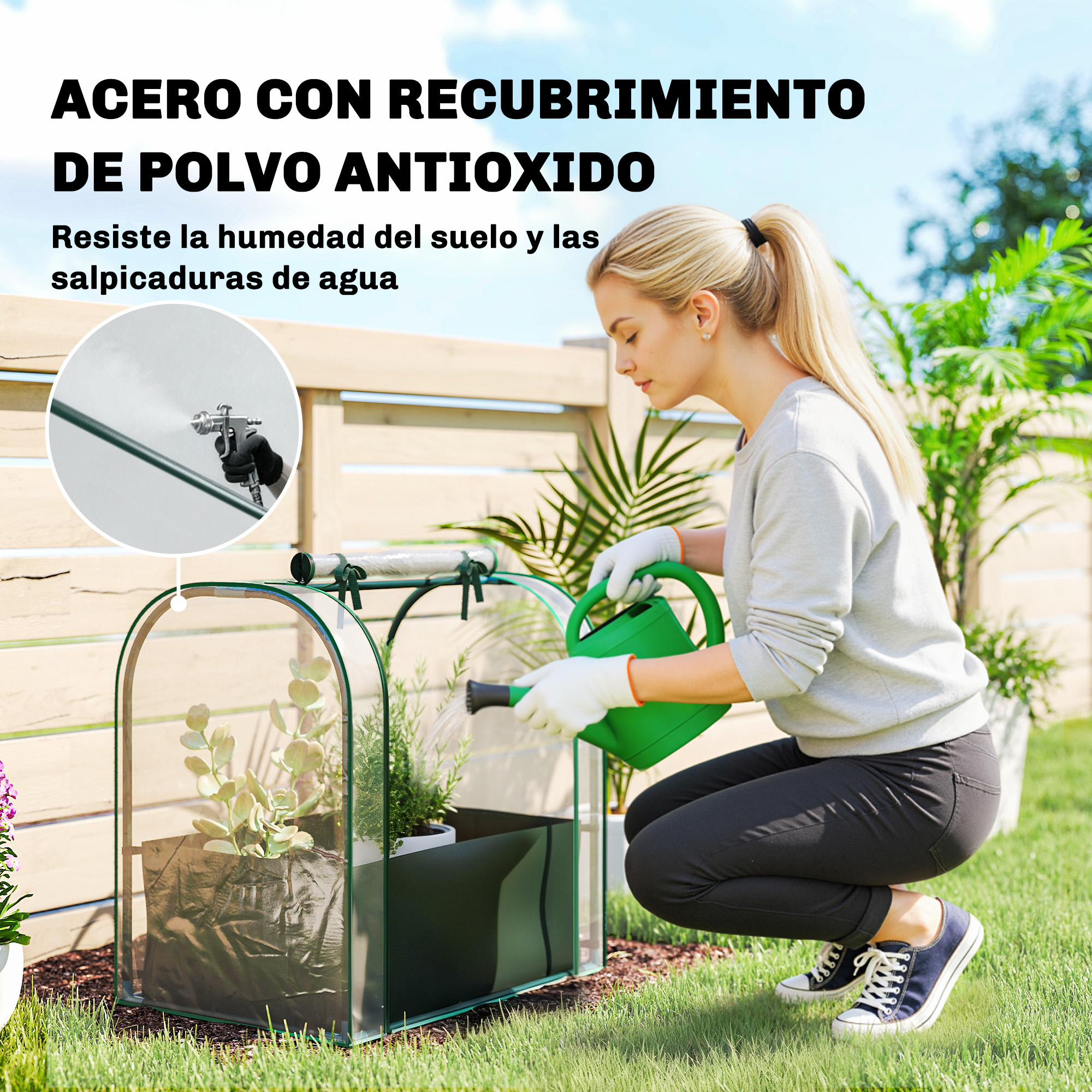 Una mujer riega plantas en un pequeño invernadero exterior con una regadera verde.
