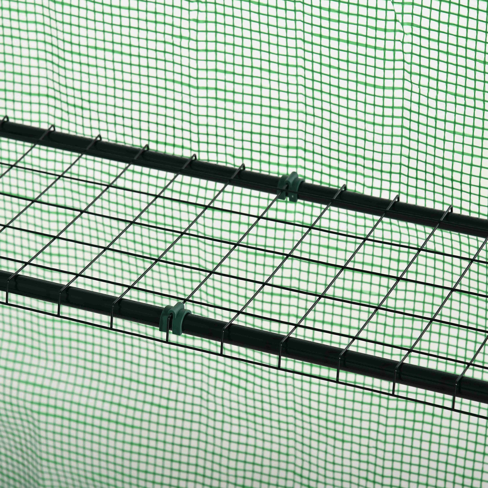 Tejido de malla verde detrás de un estante de metal negro con clips.