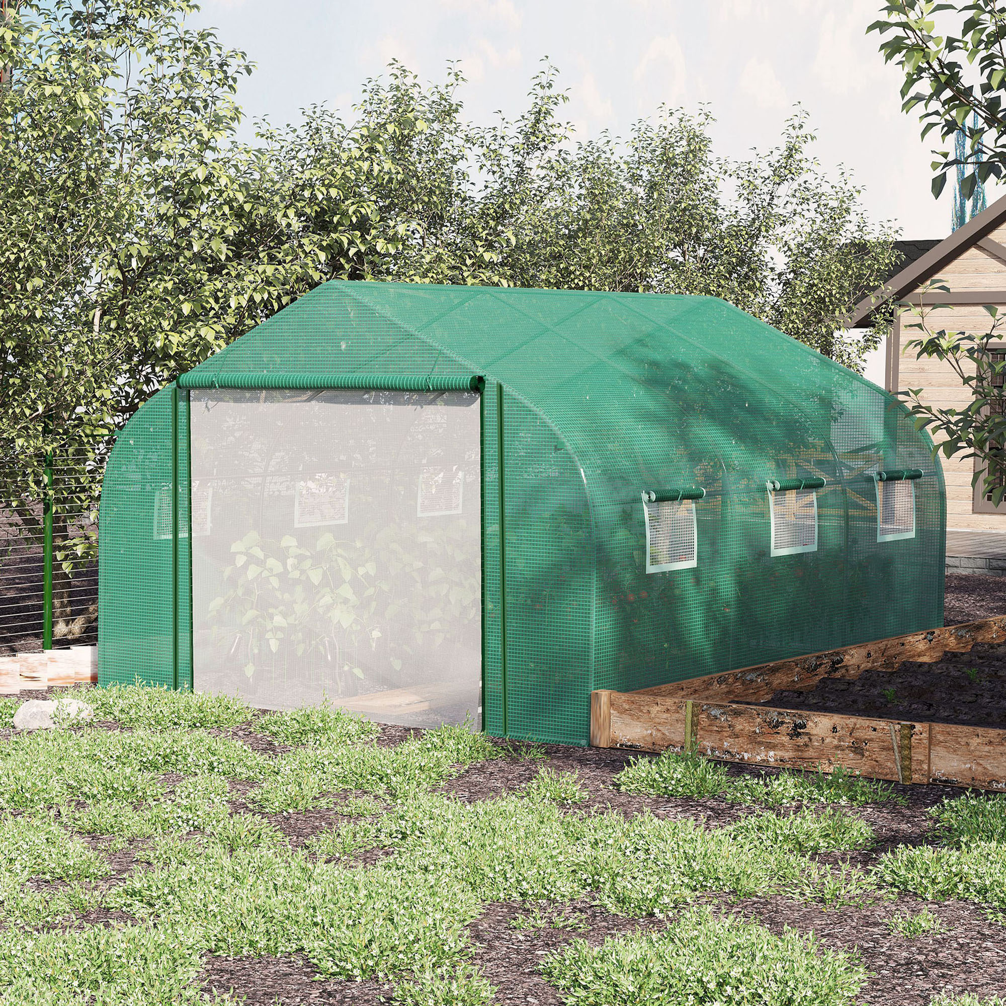 Invernadero verde con puertas y ventanas abiertas, rodeado de vegetación.