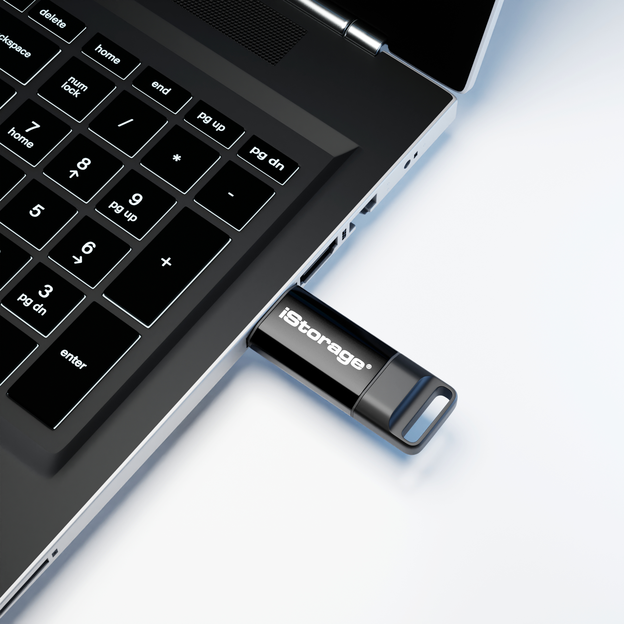 Un'unità USB iStorage nera è collegata a un laptop. Vista ravvicinata della tastiera.