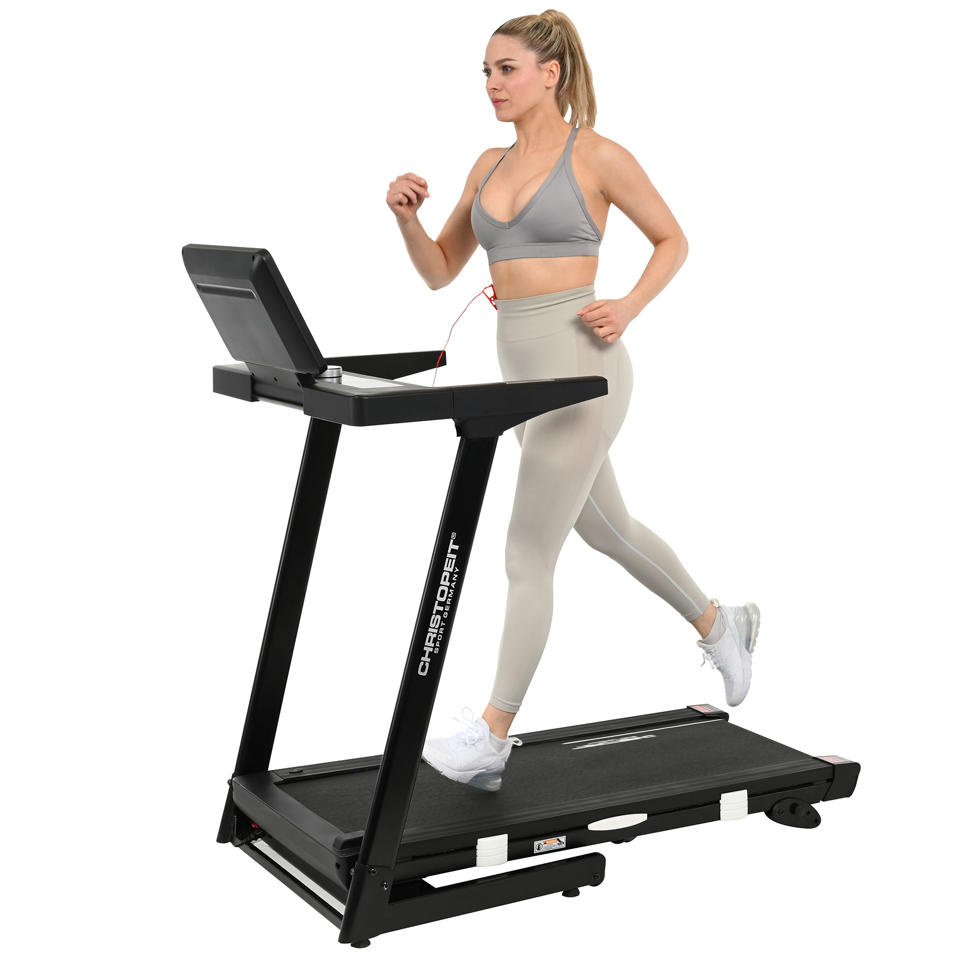 Eine Frau in Sportkleidung läuft auf einem schwarzen Laufband.