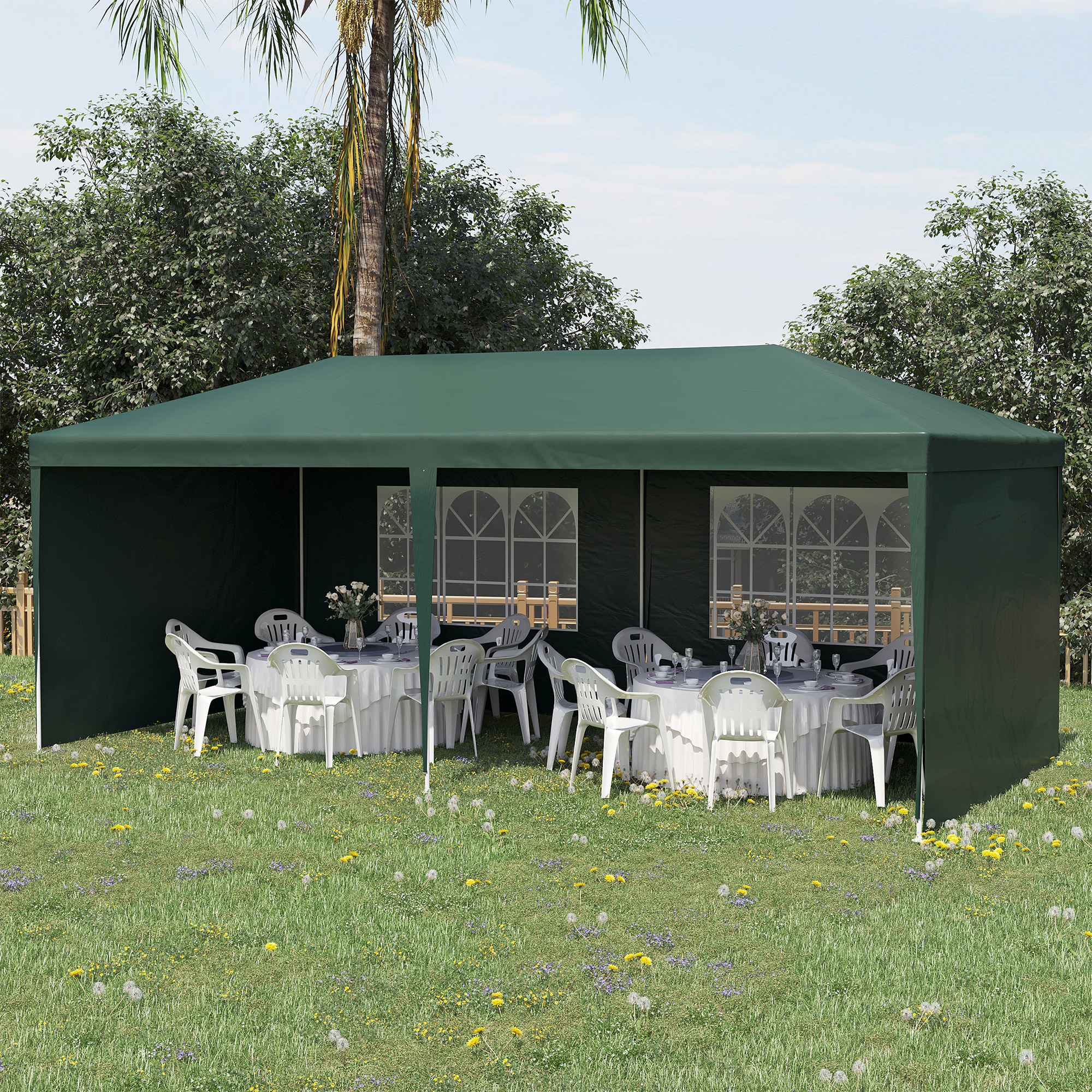 Una tenda verde con tavoli e sedie di plastica bianche su un prato.