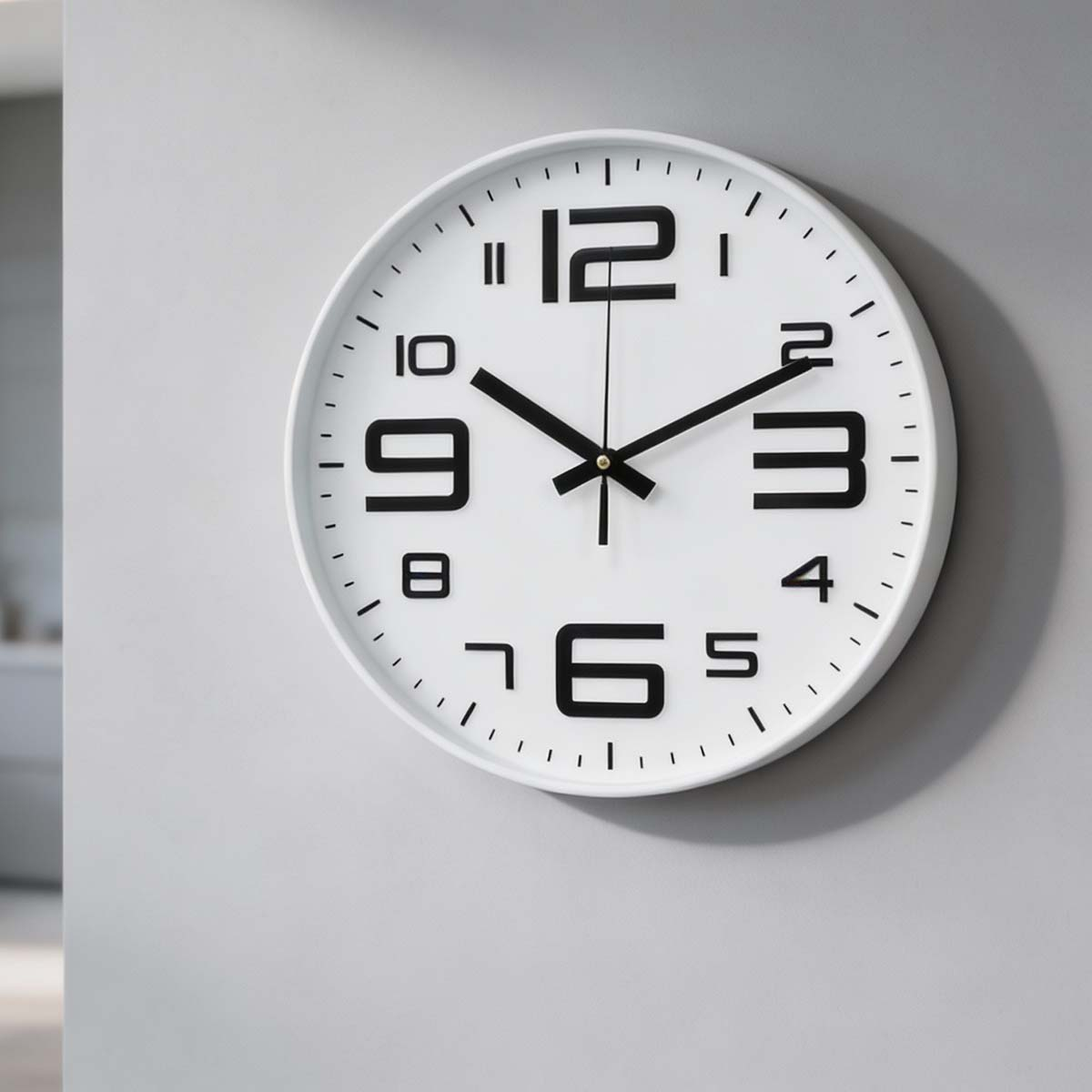 Eine weiße Wanduhr mit schwarzen Ziffern und Zeigern, die auf 10:10 Uhr zeigt.
