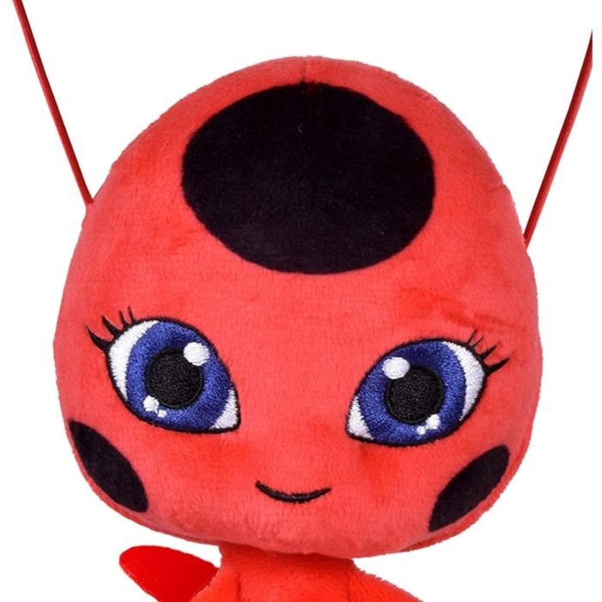 Peluche coccinelle rouge avec de grands yeux bleus et des points noirs.