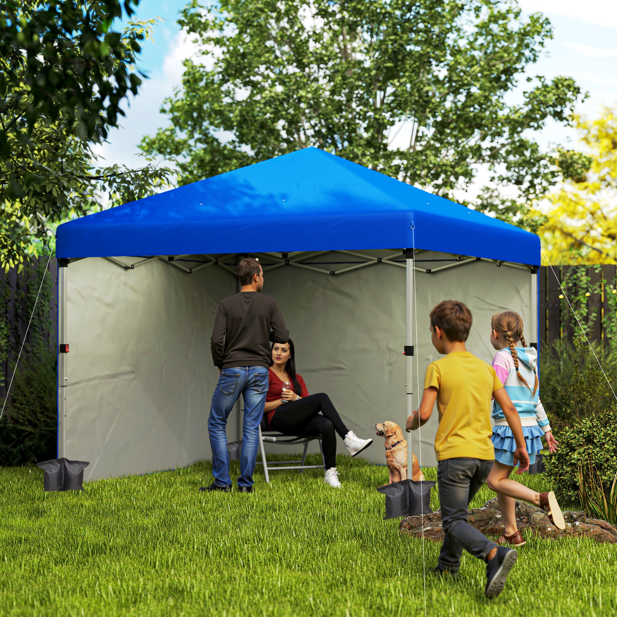 Familia y perro bajo un toldo azul en un jardín.