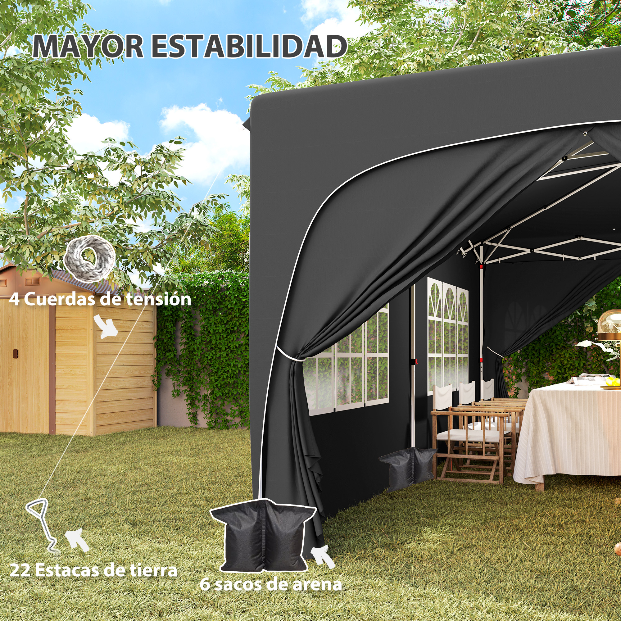 Carpa negra en jardín con mesa, sillas, estacas y sacos de arena.