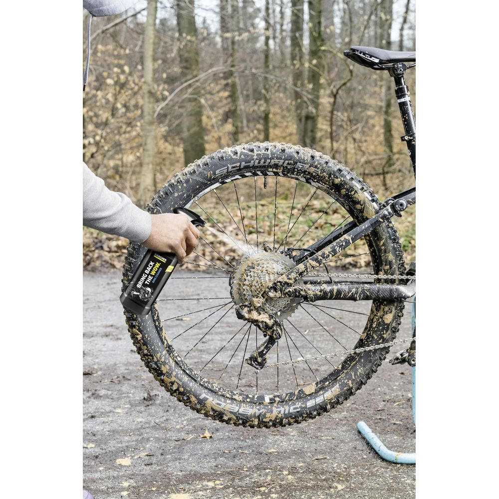 Persona spruzza fango da una bicicletta. Bosco sullo sfondo.