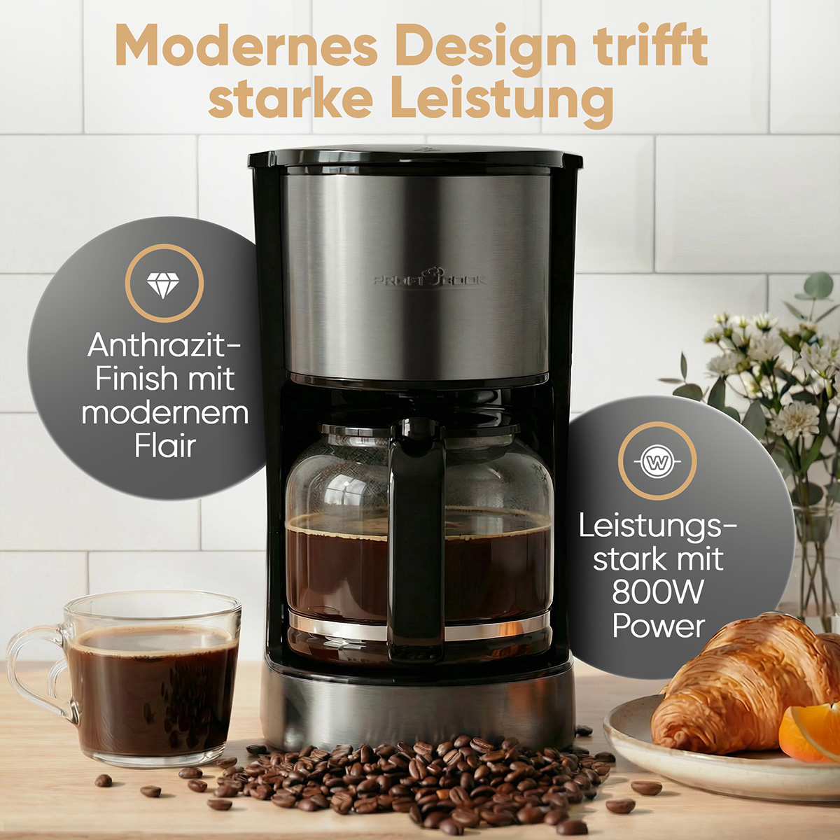 Macchina da caffè con caraffa in vetro, tazza, caffè e croissant.