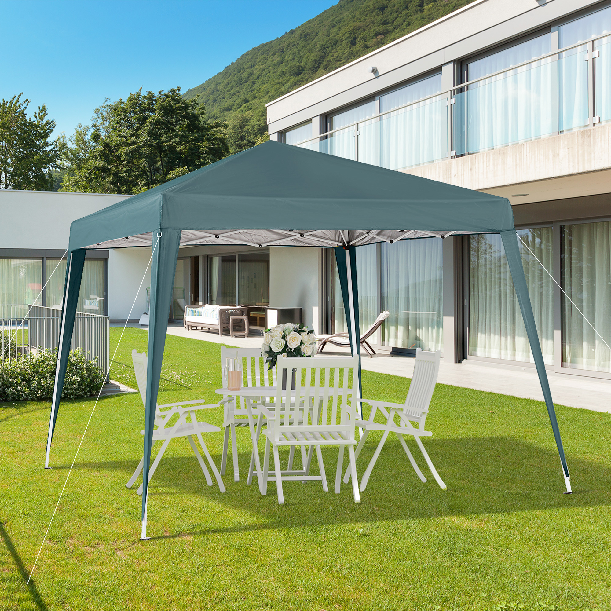 Un toldo azul sobre césped verde frente a una casa moderna.