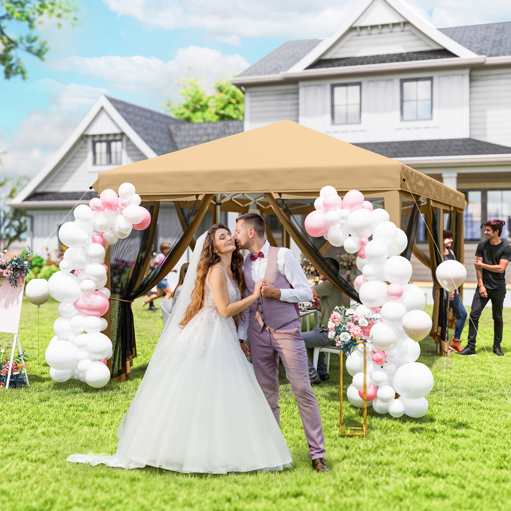 Coppia di sposi si bacia davanti a un gazebo con palloncini, casa sullo sfondo.