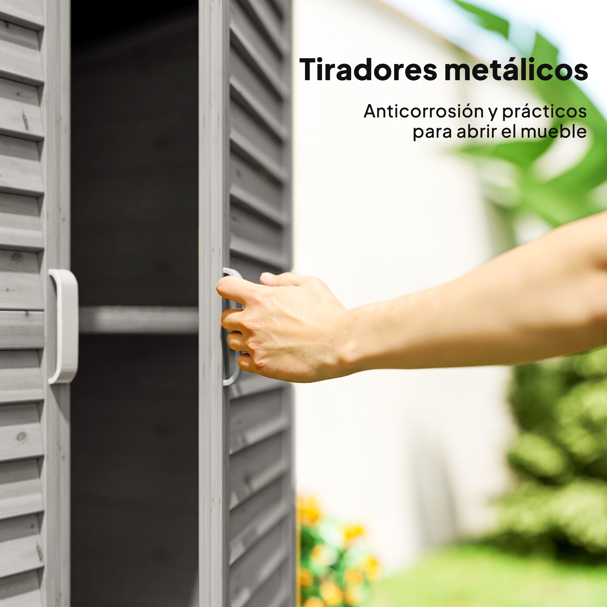 Una mano abre una puerta de madera con un tirador metálico. Hay un jardín fuera.