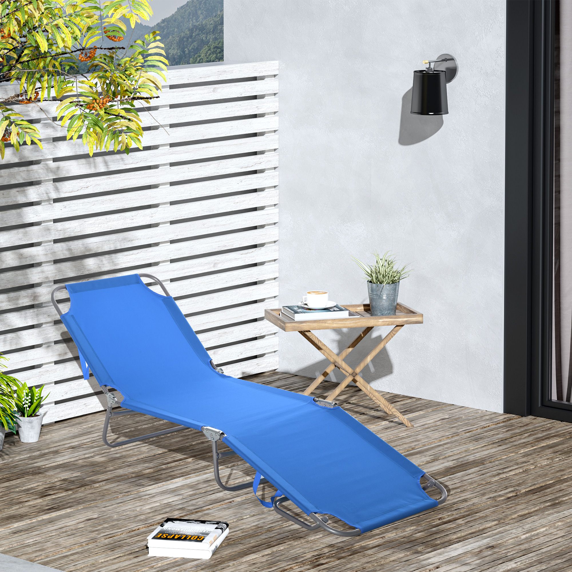 Una tumbona azul en una terraza de madera junto a una mesa con taza de café y planta.