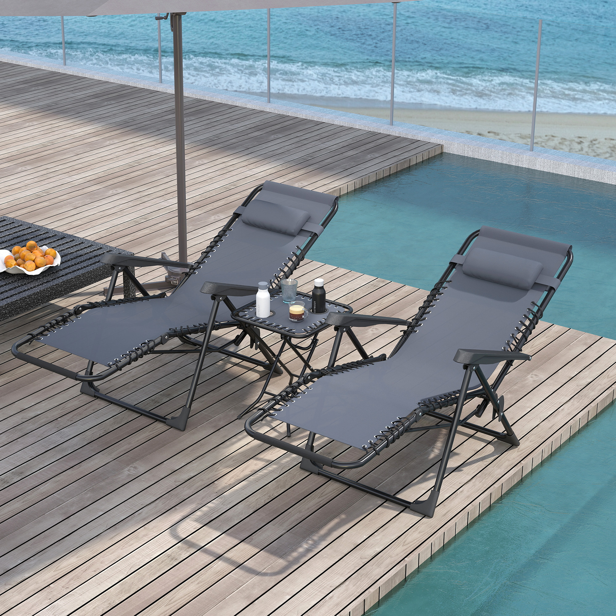 Due sedie a sdraio grigie vicino a una piscina con vista sul mare, con tavolino.