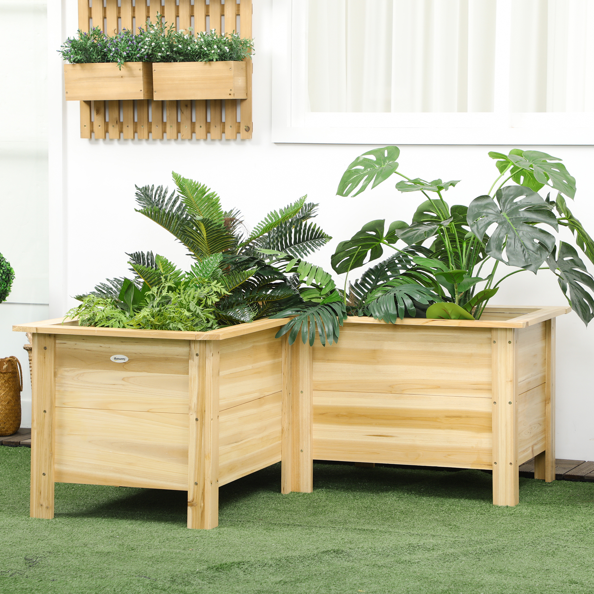 Dos jardineras elevadas de madera con plantas verdes sobre césped artificial.