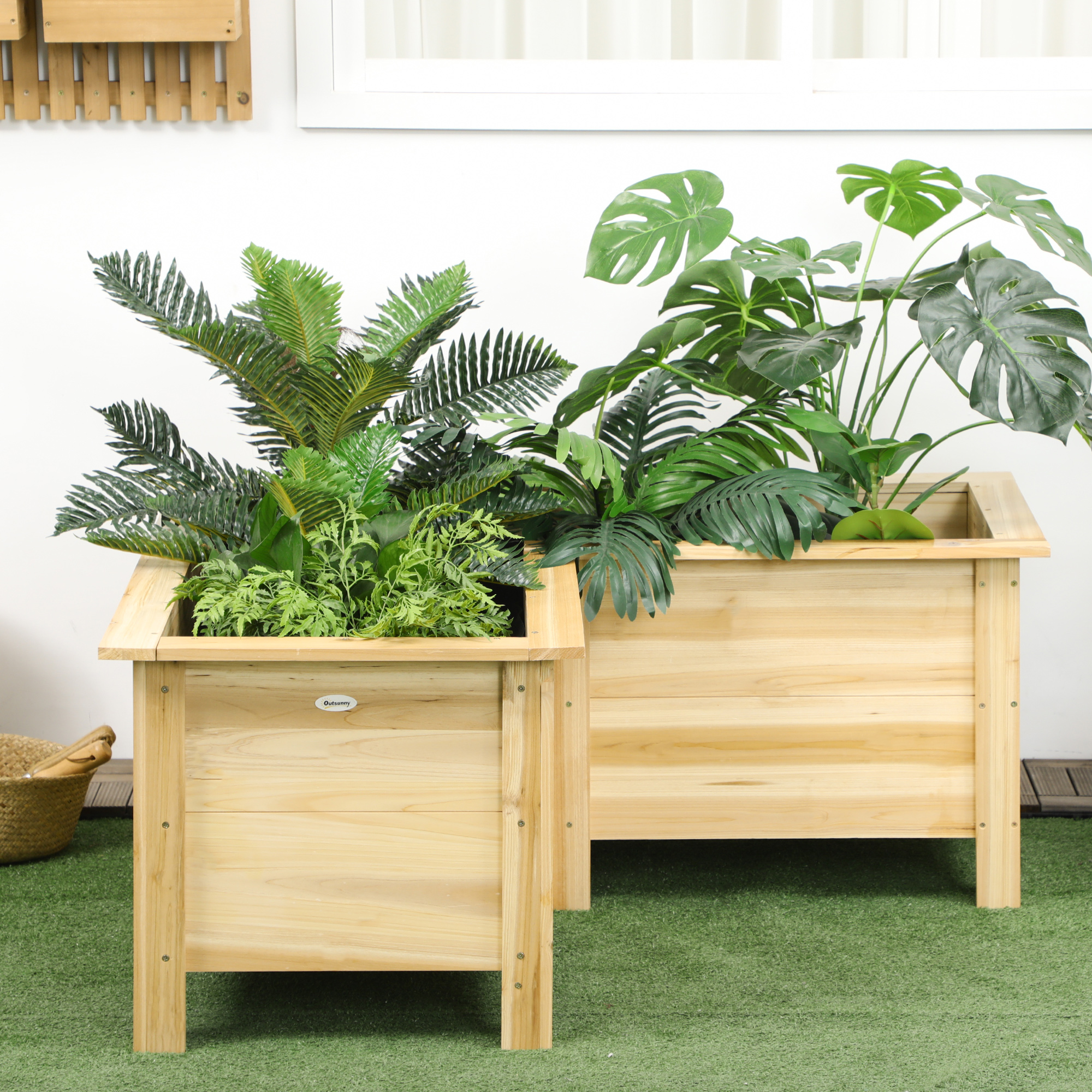 Dos jardineras de madera con plantas verdes sobre césped artificial.