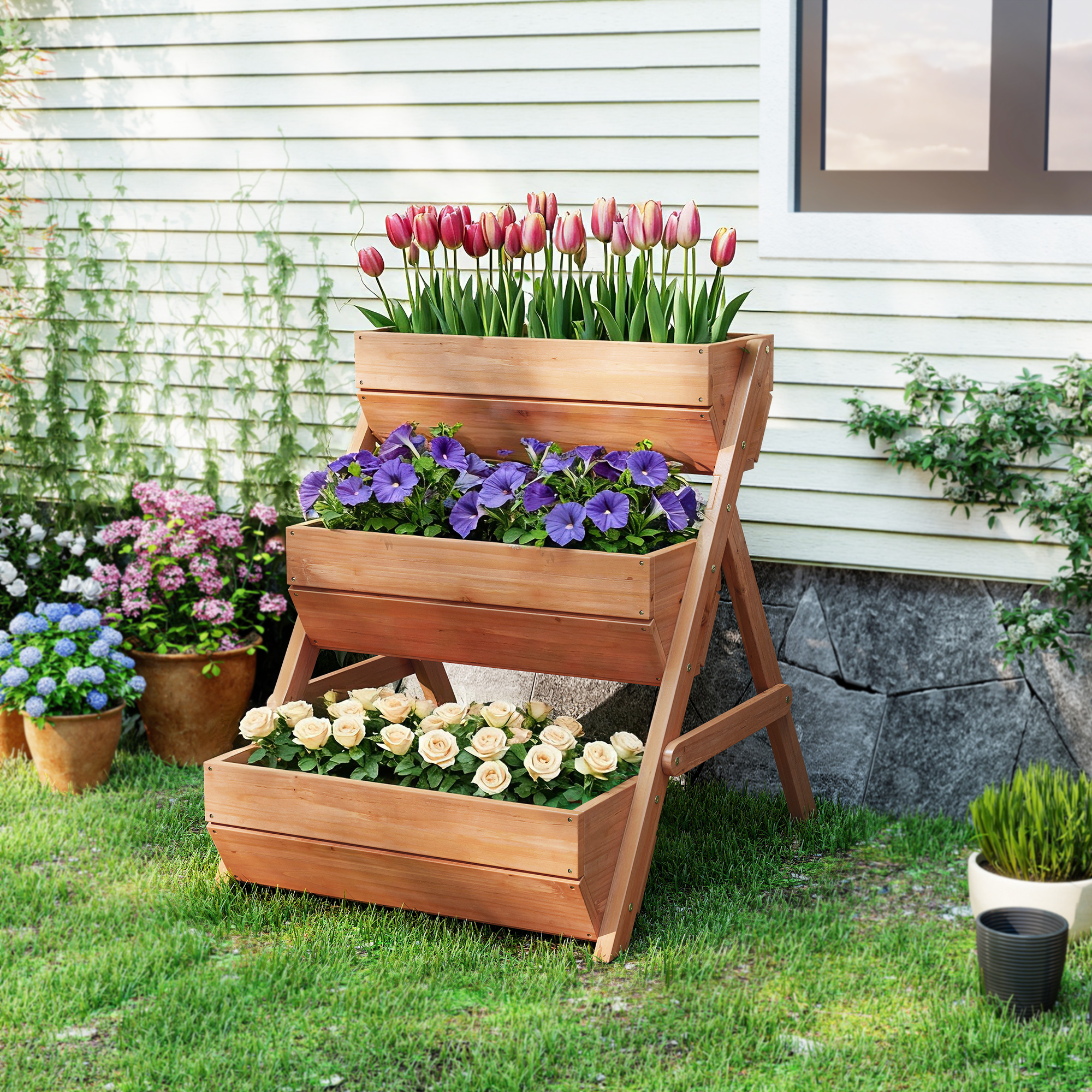 Un macetero de madera de tres niveles lleno de tulipanes, petunias y rosas.