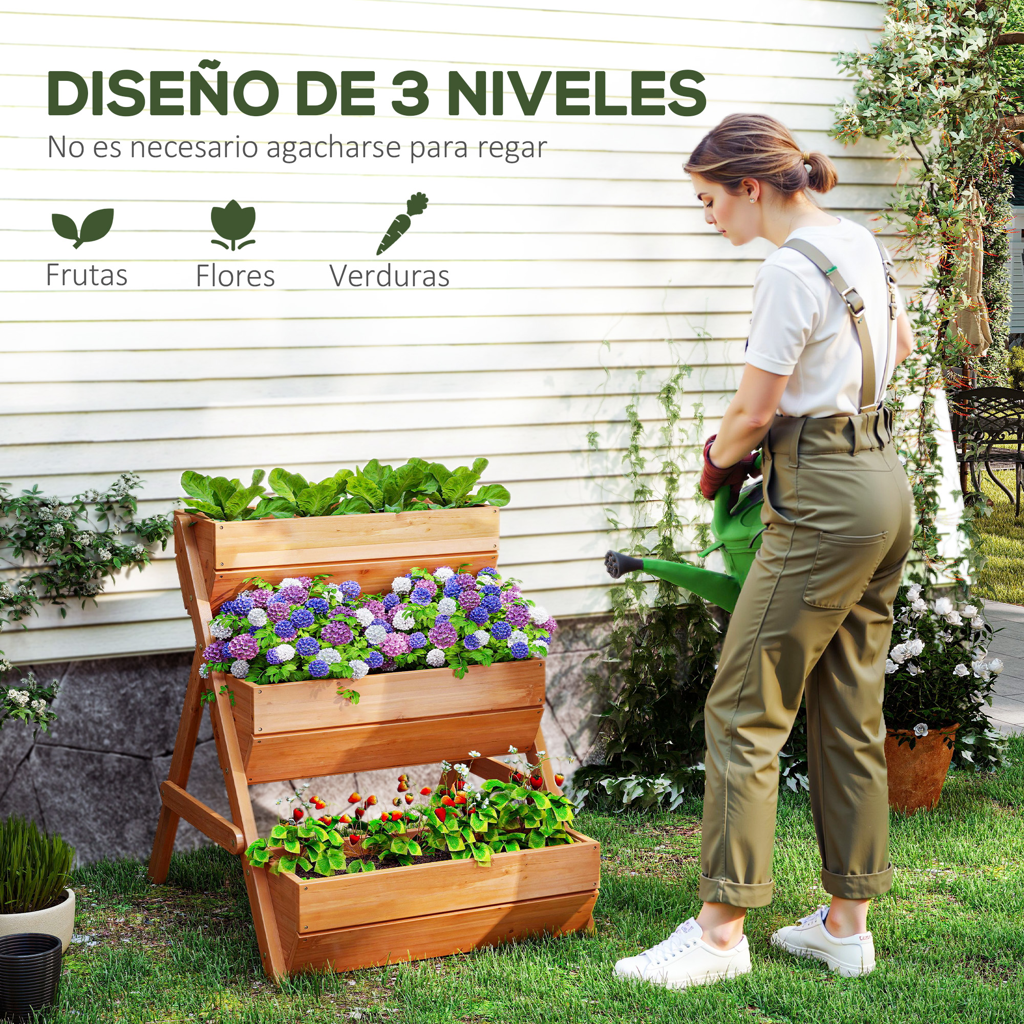 Mujer riega macetero de tres niveles con flores y verduras en un jardín.