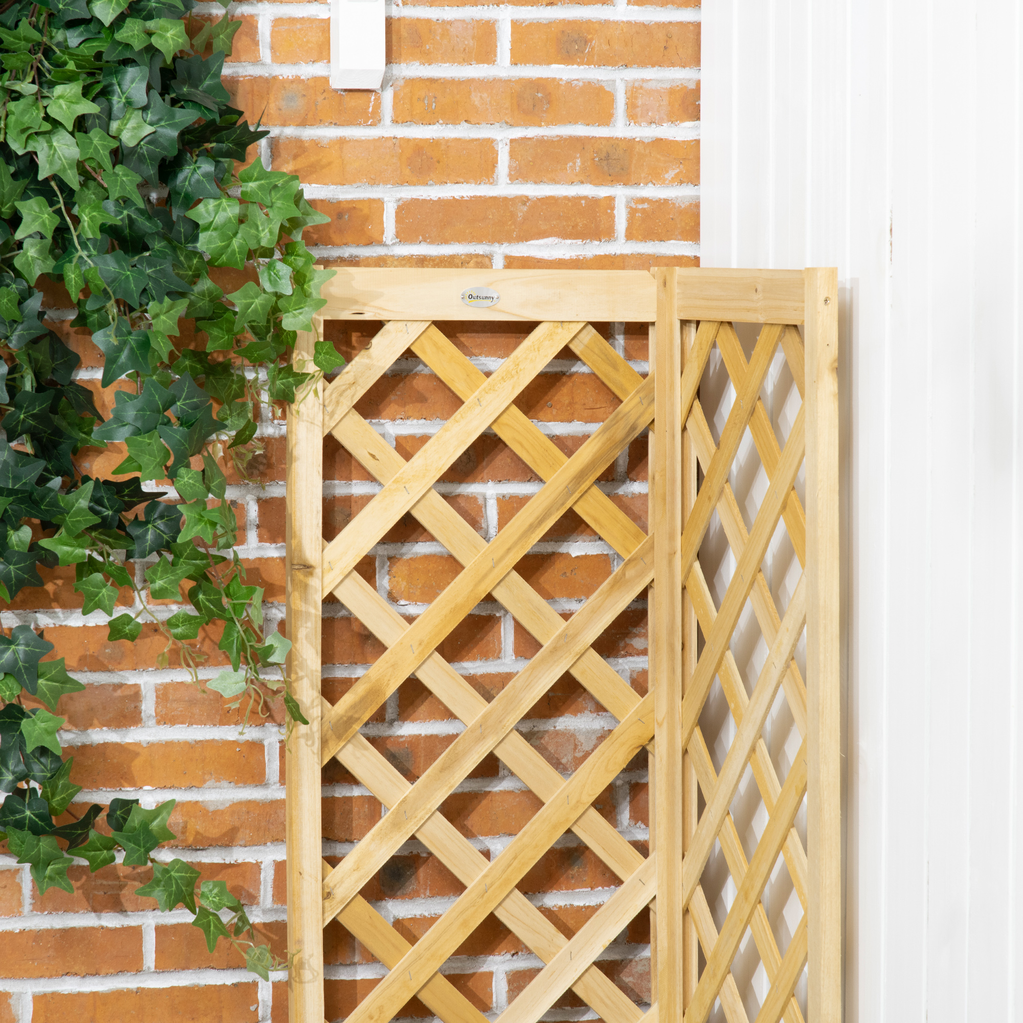 Hiedra verde crece sobre una celosía de madera contra una pared de ladrillos.
