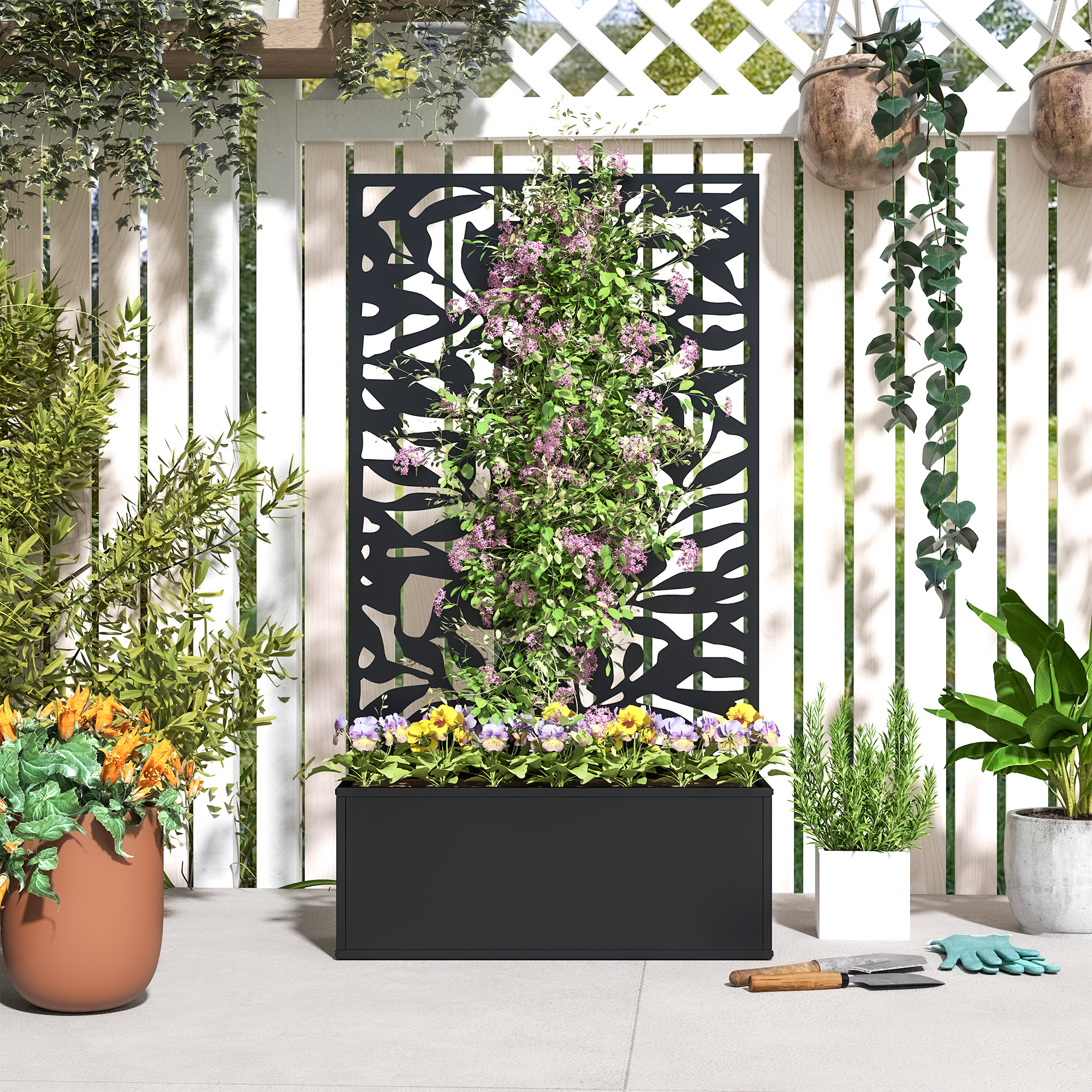 Un área plantada con flores y plantas verdes frente a una valla de listones.