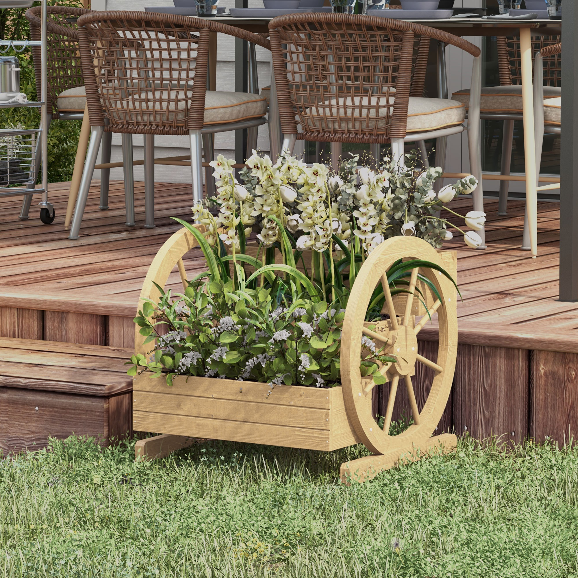 Macetero de madera con diseño de rueda de carro y flores blancas y verdes en una terraza.