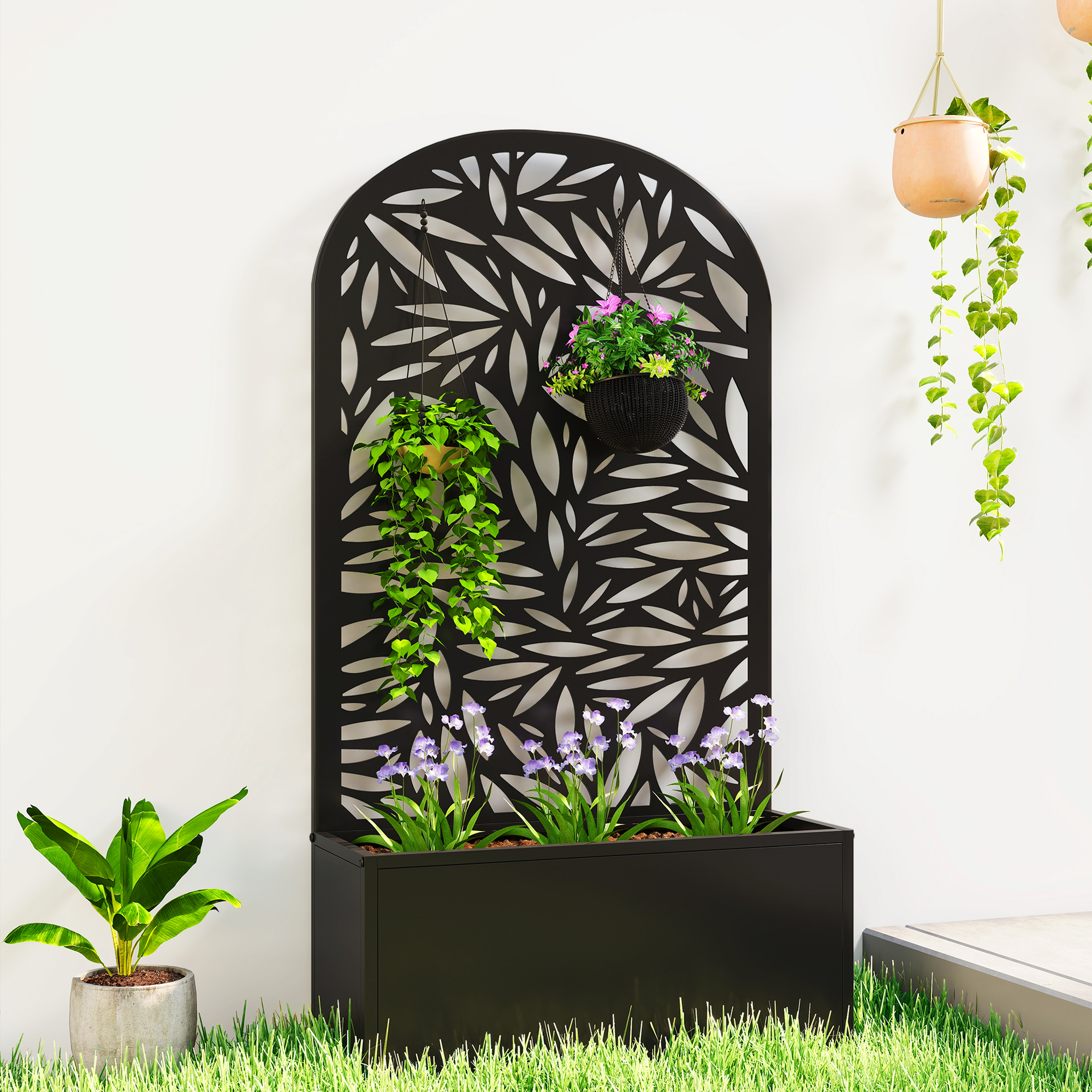 Macetero negro con flores y panel decorativo; plantas colgantes.