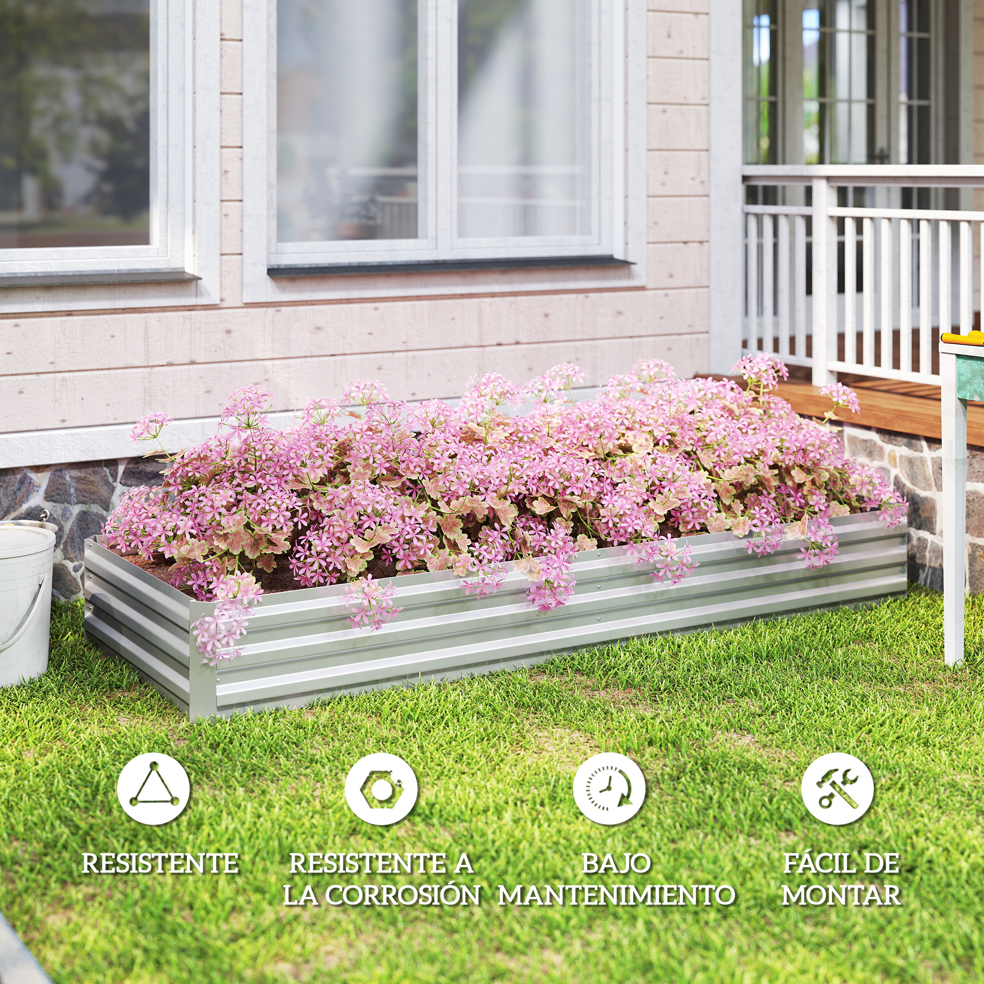 Un bancal elevado rectangular con flores rosas frente a una casa.