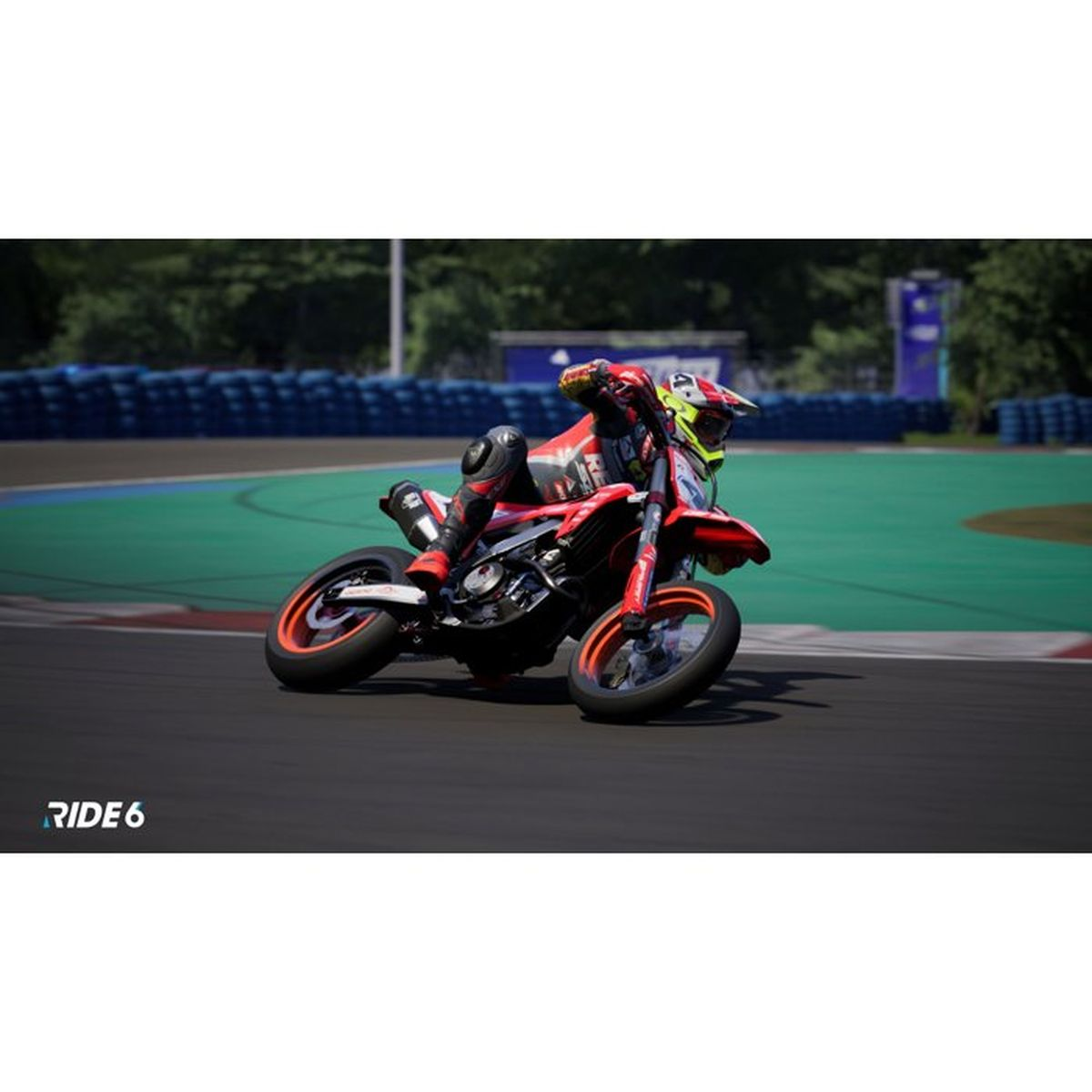 Motocyklista na torze wyścigowym pochylony w zakręcie. Czerwono-czarny strój.