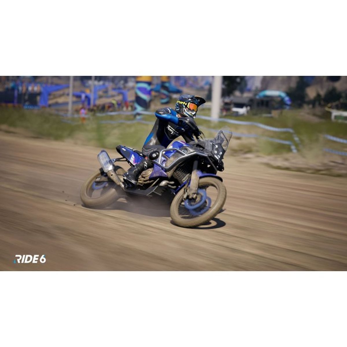 Motocyklista na niebieskim motocyklu ściga się po torze szutrowym.