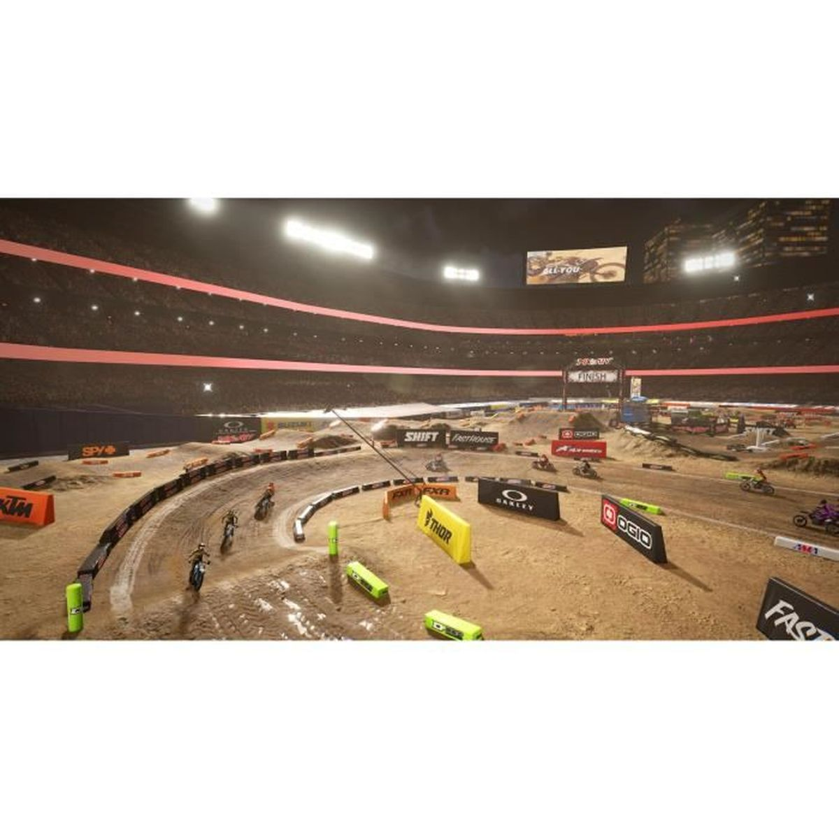 Pista di motocross con piloti in uno stadio di notte, illuminata da riflettori.