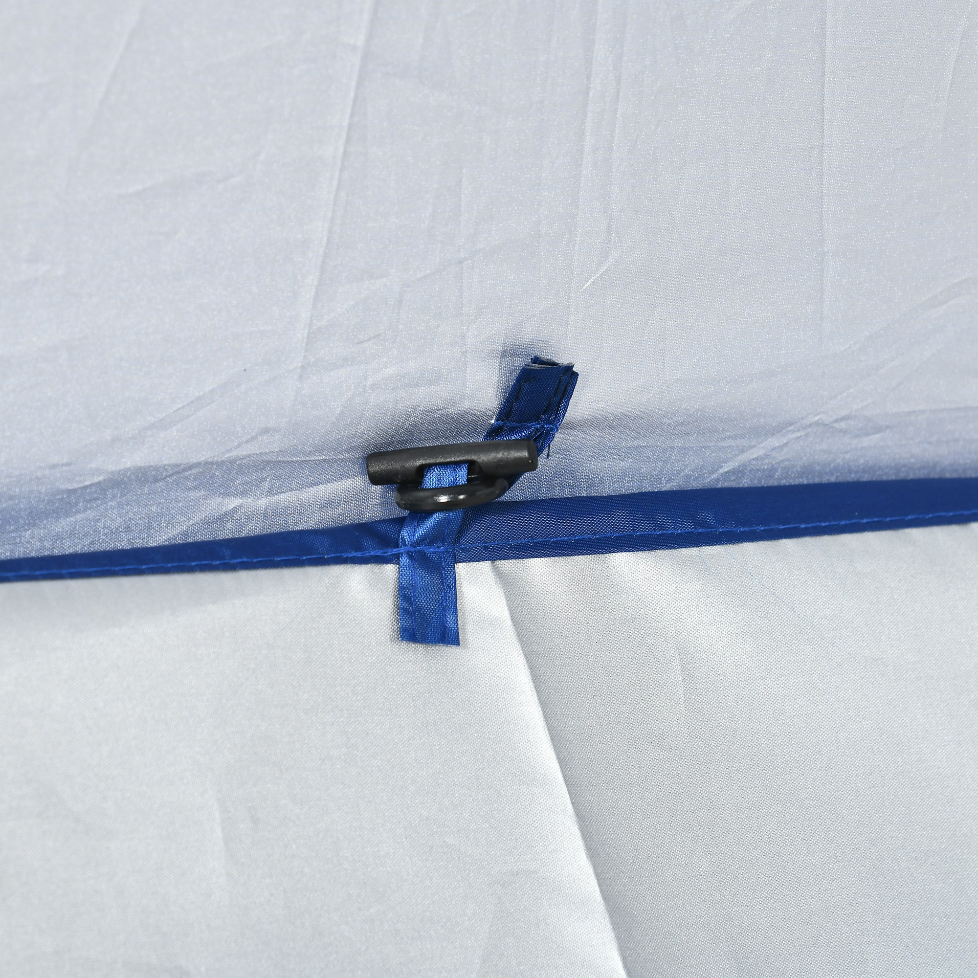 Una clip nera trattiene un cinturino blu su tessuto bianco con profili blu.