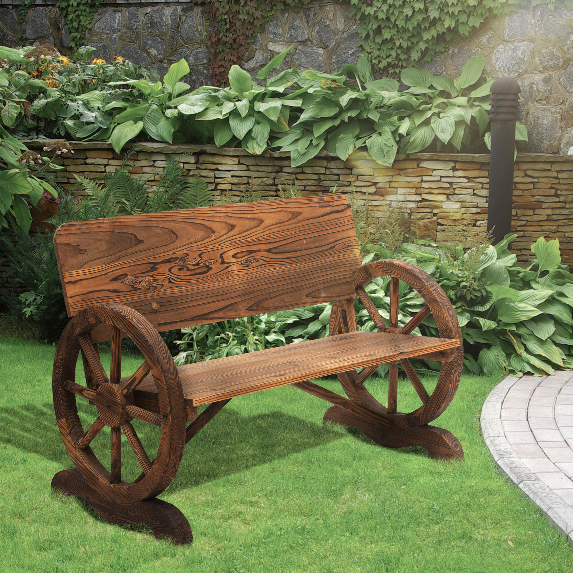 Panchina in legno con ruote di carro in un giardino sull'erba, con muro di pietra e piante.