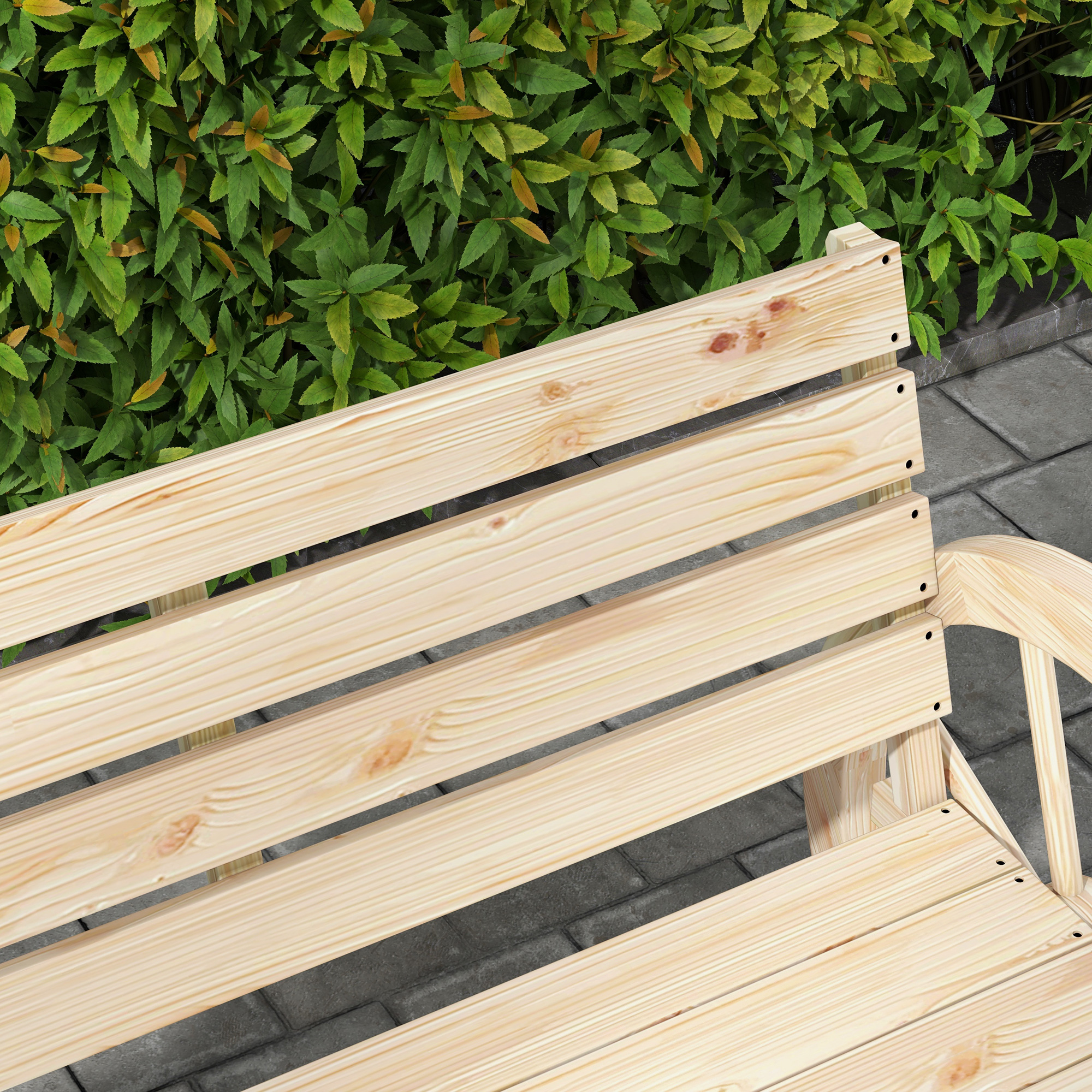 Panchina di legno davanti a cespugli verdi su un sentiero pavimentato.