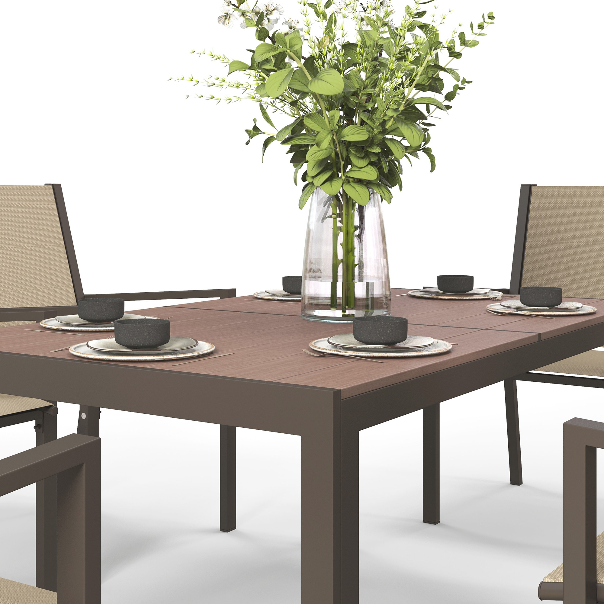 Una mesa de comedor puesta para cuatro con un jarrón de flores en el centro.