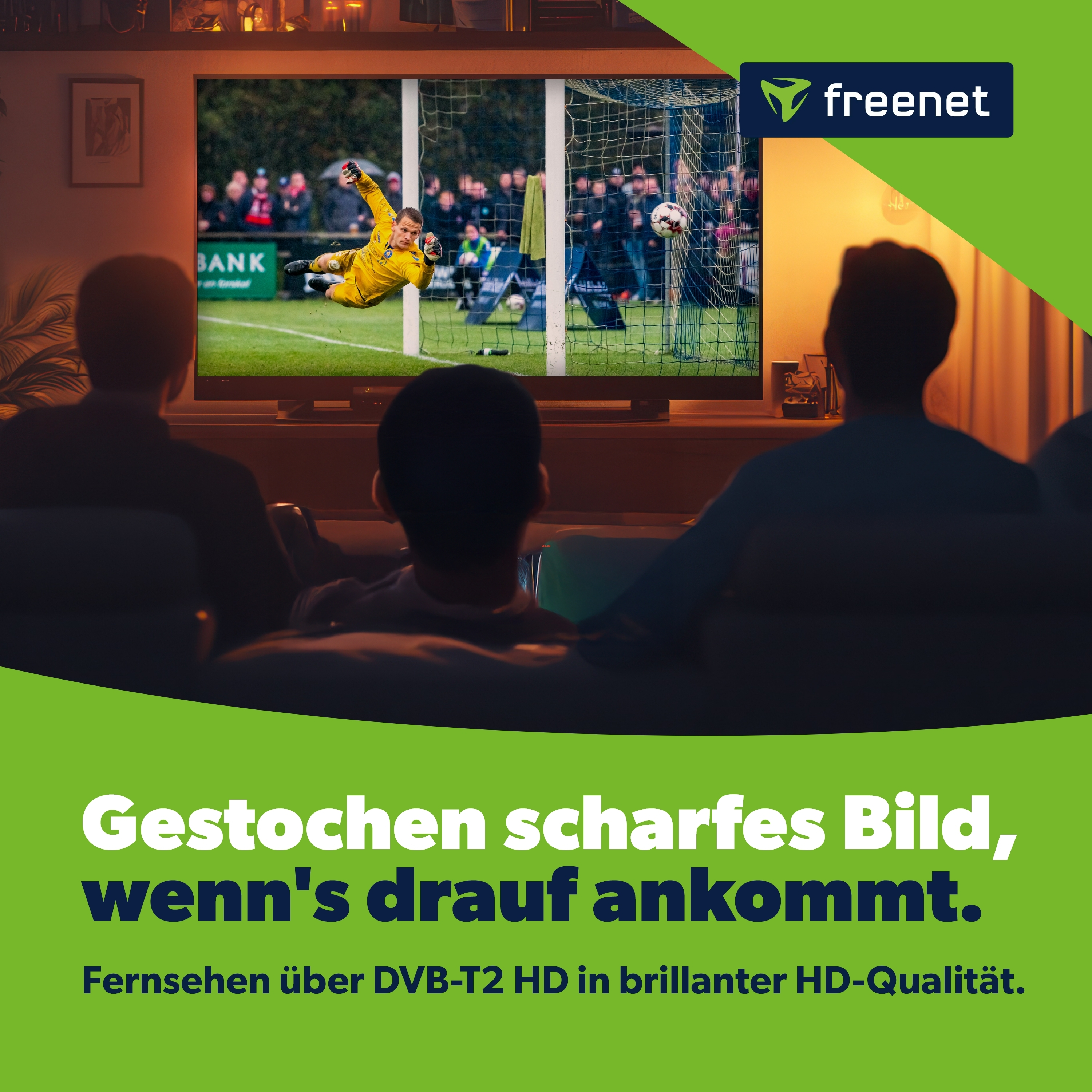 Ein Torwart springt nach dem Ball, während Zuschauer im Hintergrund zusehen.