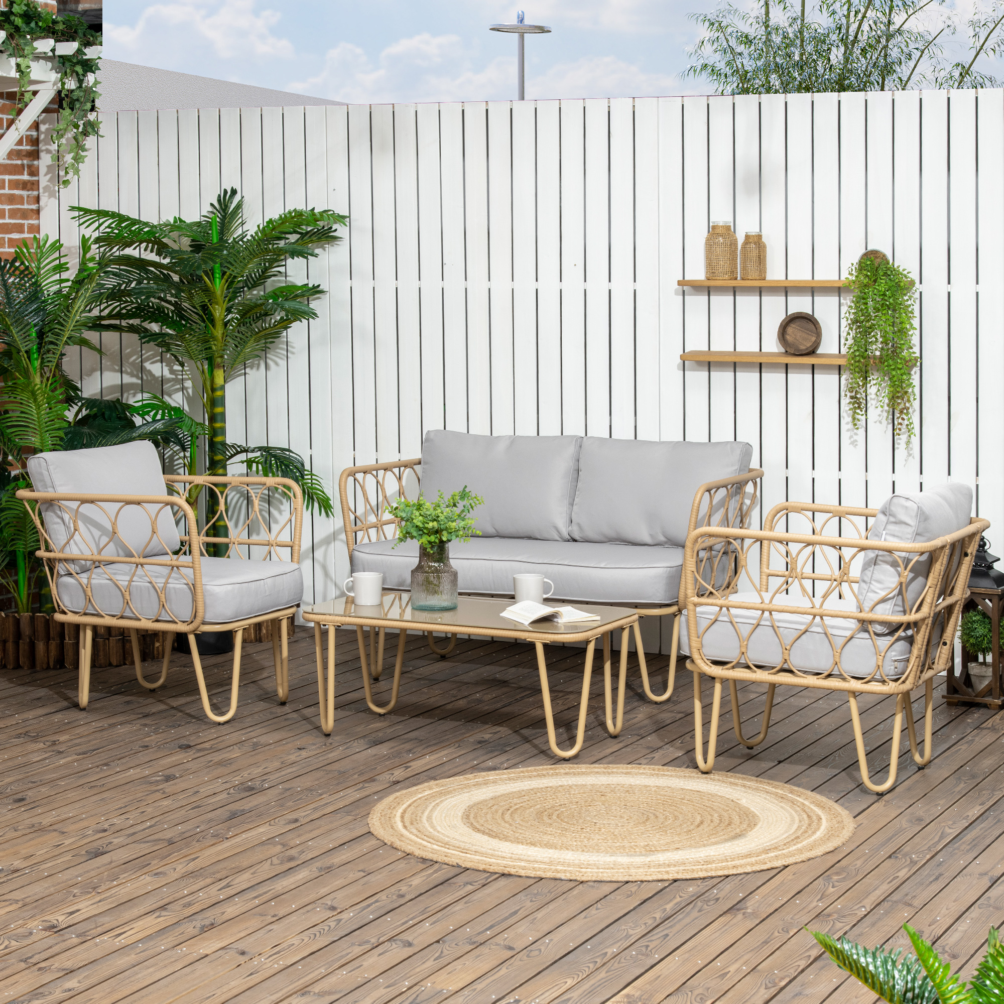 Conjunto de muebles de ratán tejido con cojines grises en cubierta de madera.