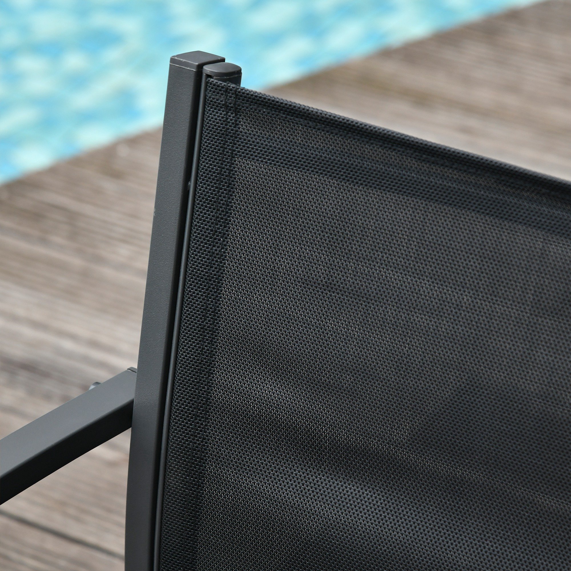 Primo piano di tessuto a rete nero su una sedia vicino a una piscina.