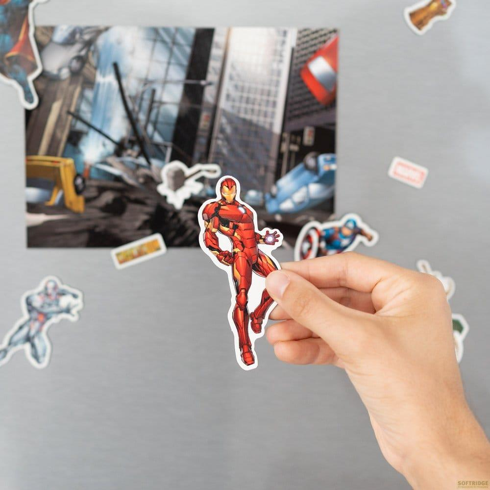 Hand hält Iron Man-Aufkleber vor einer Stadtkulisse mit Zerstörung.