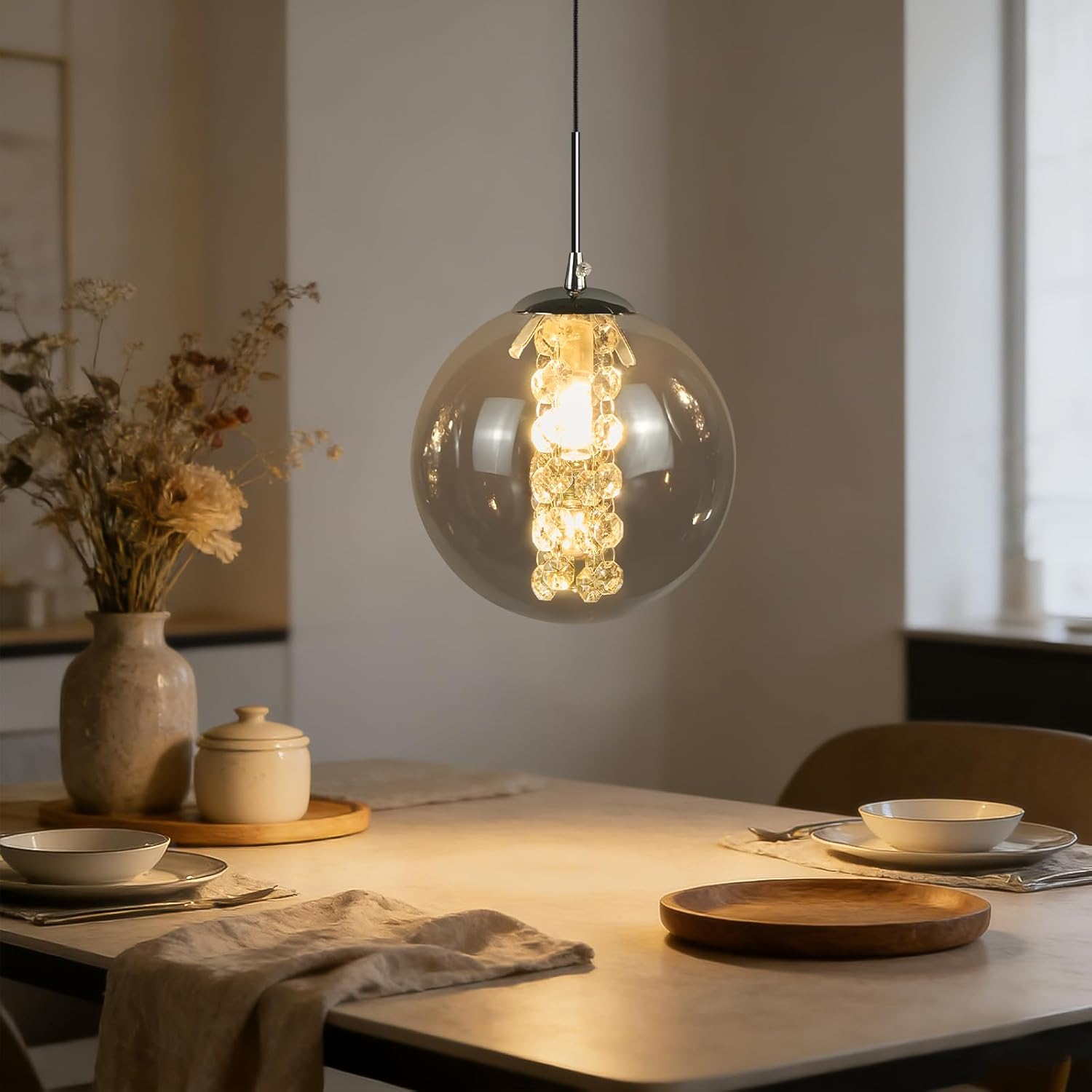 Una lampada a sospensione sferica in vetro fumé con accenti scintillanti.