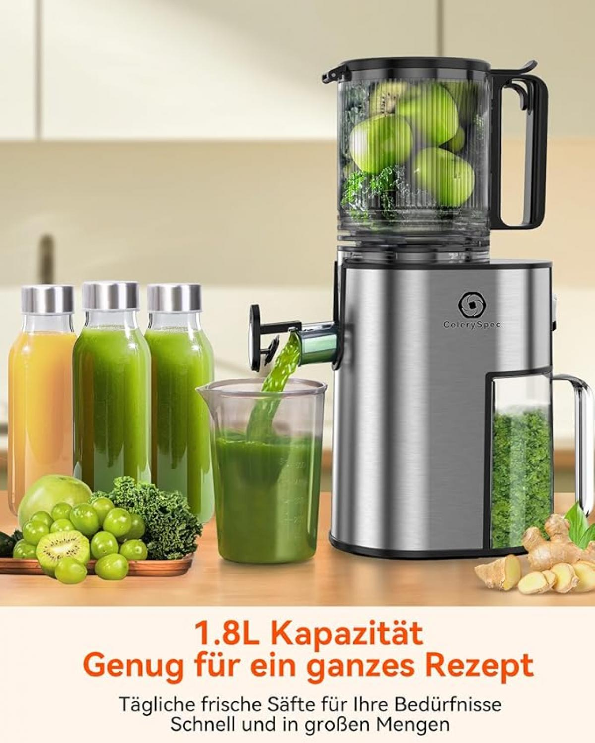 Ein Entsafter mit Äpfeln im Behälter, daneben Säfte, Obst und Ingwer.